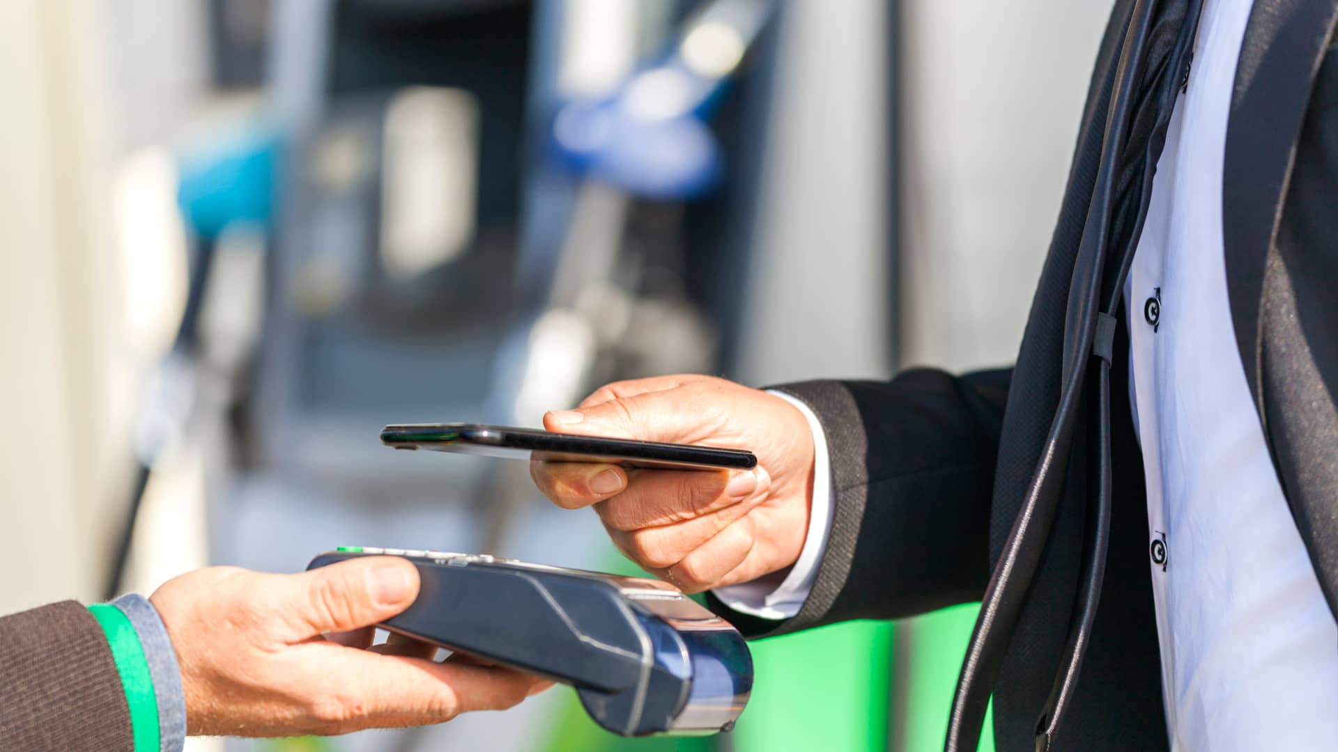 Hombre realiza un pago mediante su teléfono móvil en una gasolinera tras adquirir biodiésel