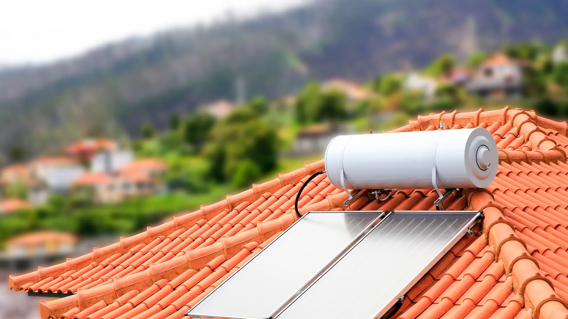 Paneles solares con calentador de agua que posteriormente irá a un tanque acumulador de agua en el tejado de una casa en Madeira, Portugal Paneles solares con calentador de agua que posteriormente irá a un tanque acumulador de agua en el tejado de una casa en Madeira, Portugal