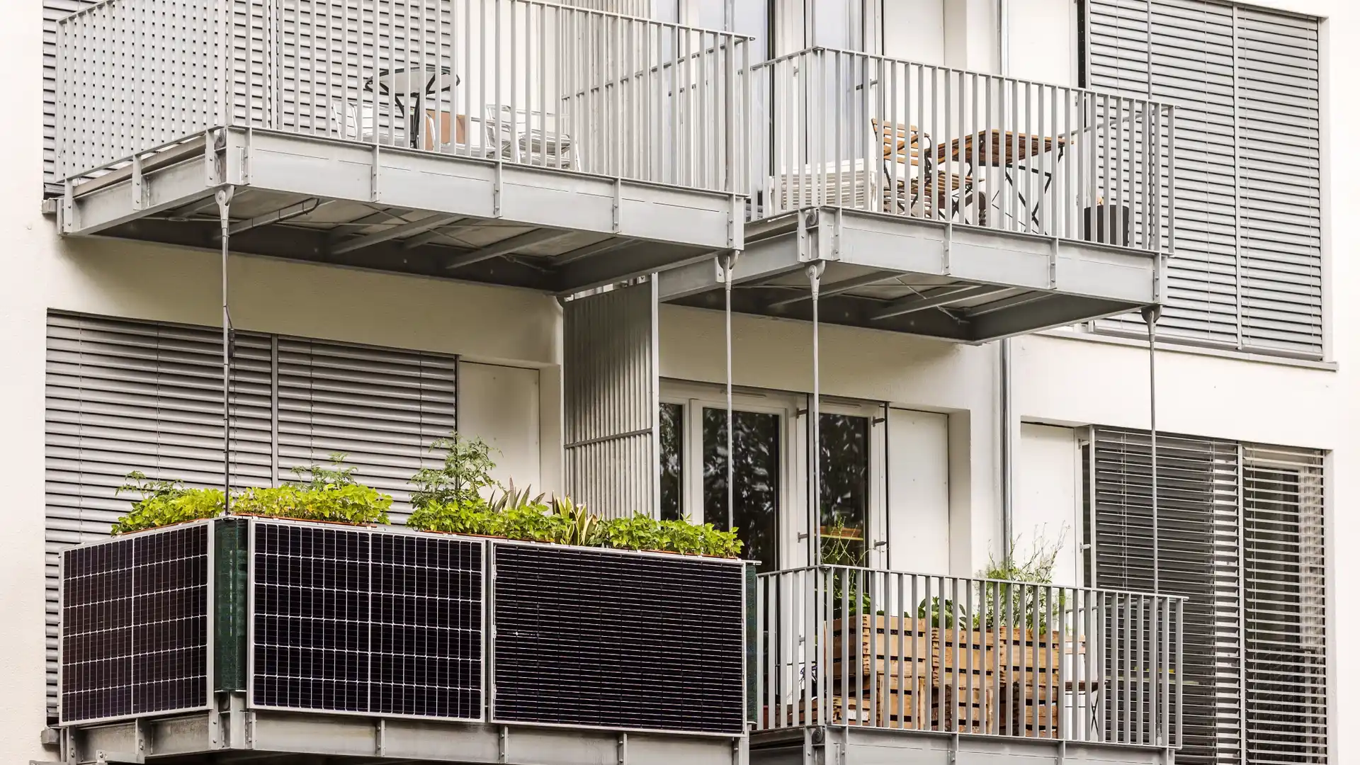 Balcon de una persona con placas solares que conoce los tipos de autoconsumo de energia solar Balcon de una persona con placas solares que conoce los tipos de autoconsumo de energia solar