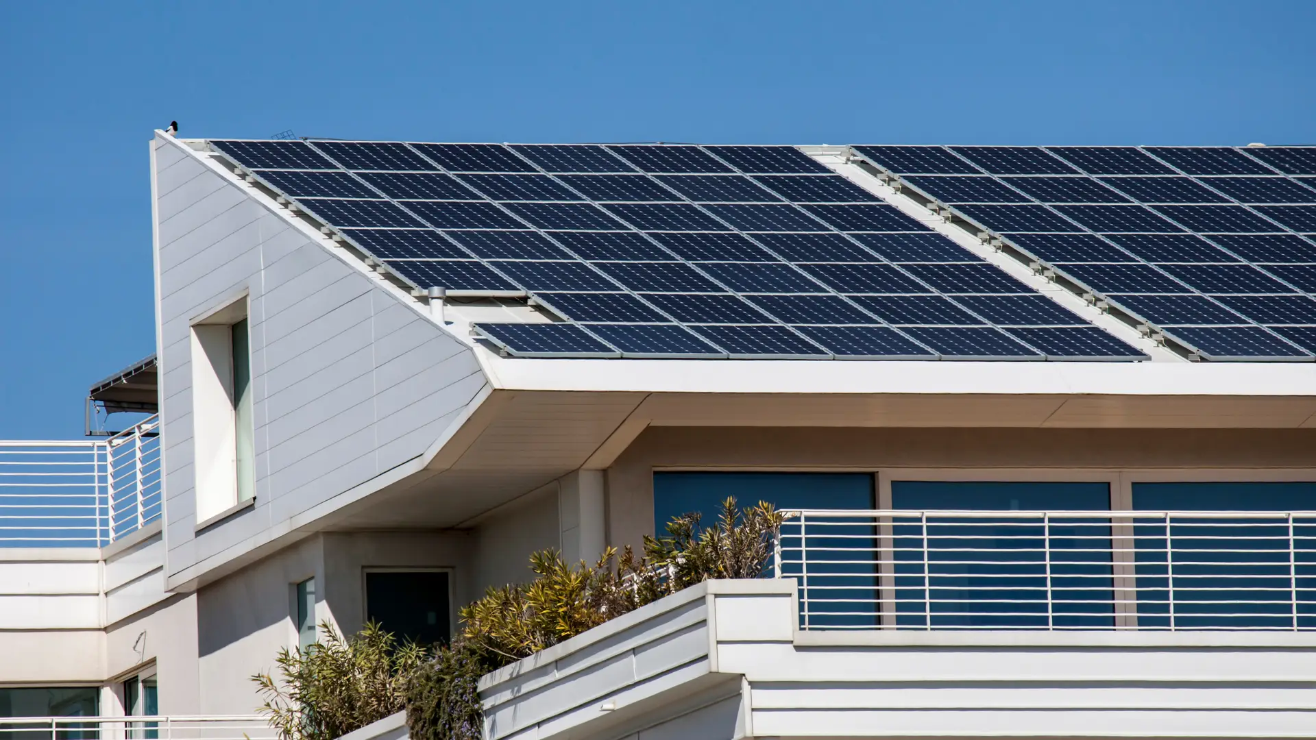 Tejado de una casa con placas solares para representar la bateria virtual de autoconsumo de energia solar