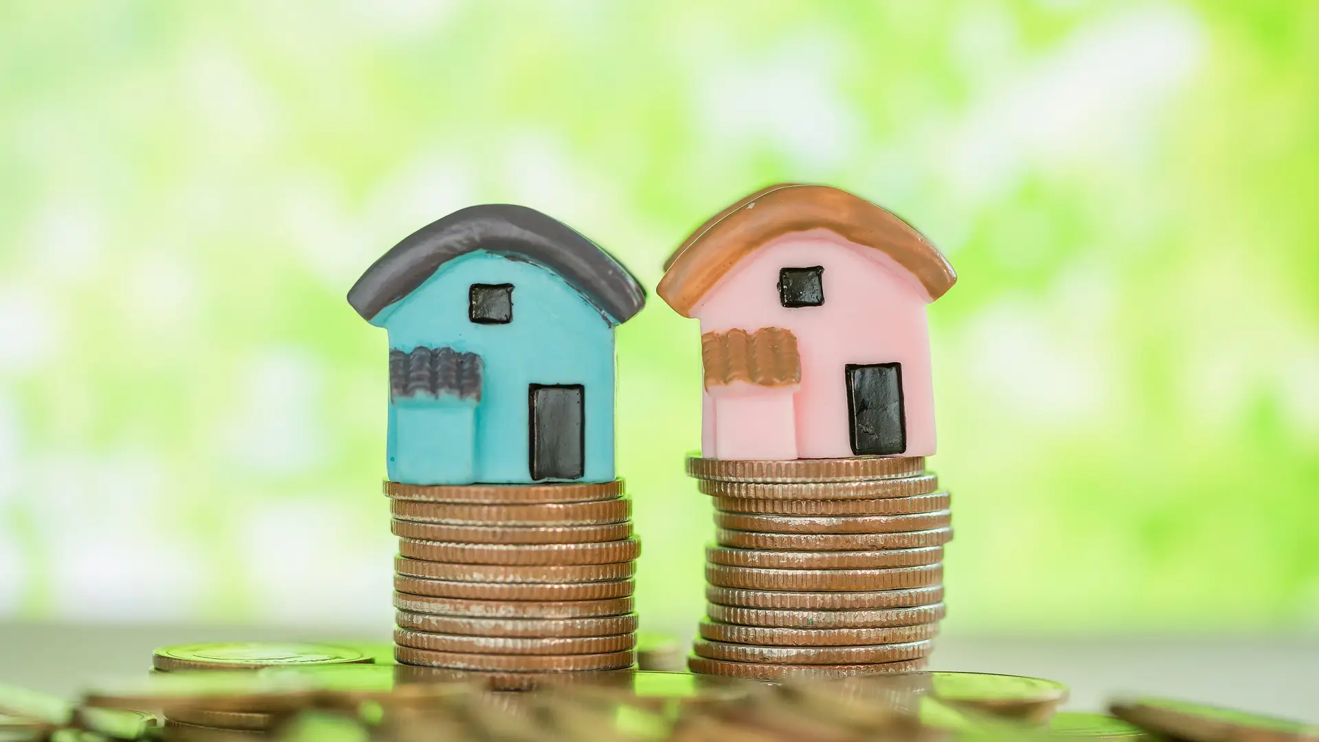 Dos casitas en miniatura descansan sobre monedas recibidas como compensación de excedentes de energía solar Dos casitas en miniatura descansan sobre monedas recibidas como compensación de excedentes de energía solar