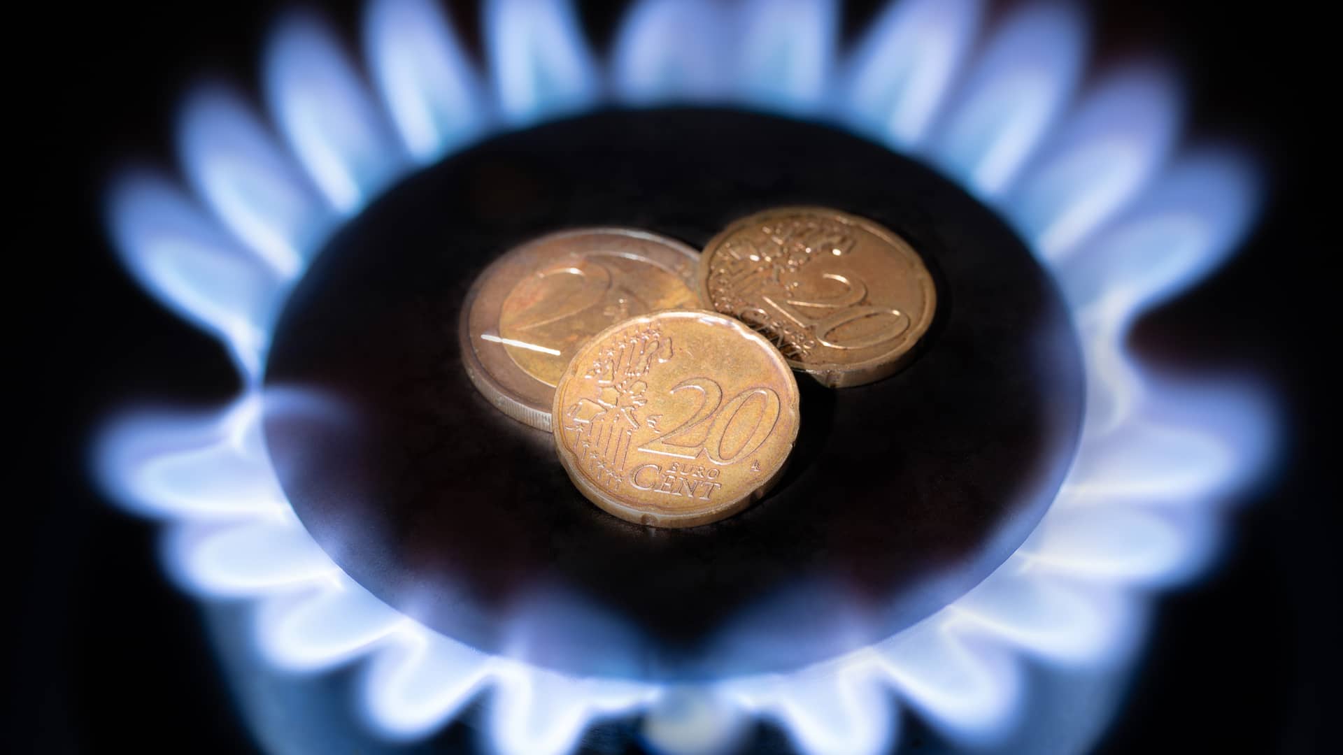 Fuego de cocina de gas con monedas de céntimo de euro en el centro, ilustra las mejores tarifas de gas natural