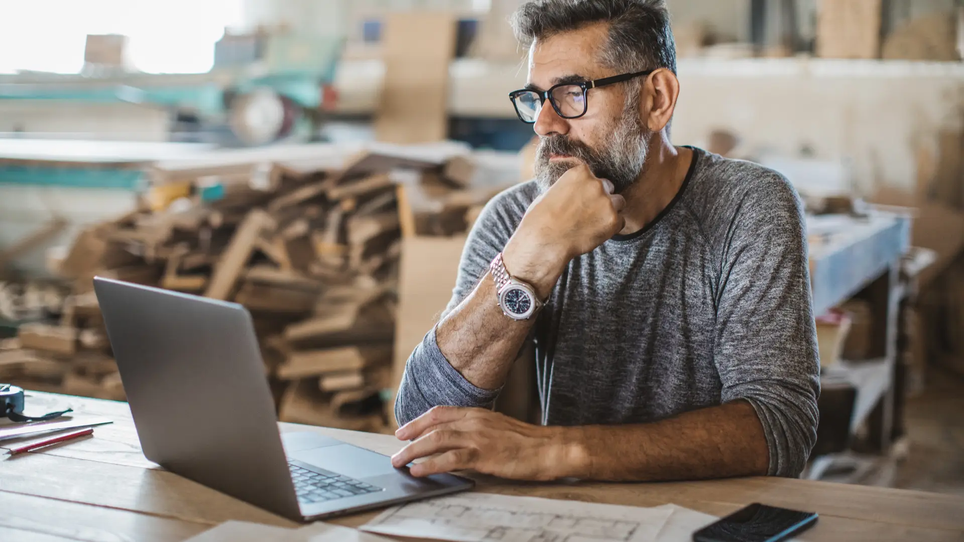 Hombre revisando facturas y presupuestos en su portátil Hombre revisando facturas y presupuestos en su portátil