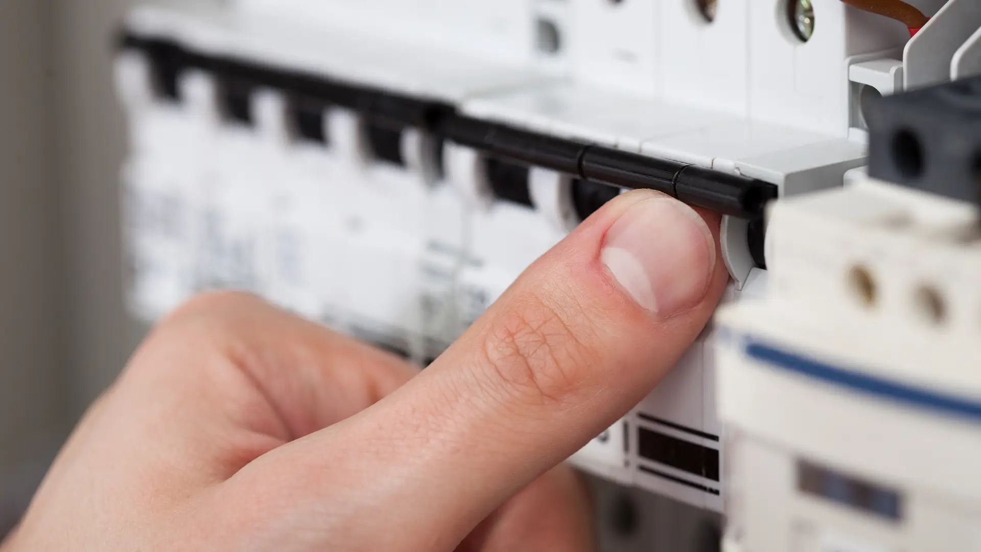 Hombre subiendo un interruptor del cuadro de luces, en el que también podemos encontrar el interruptor de control de potencia o ICP  Hombre subiendo un interruptor del cuadro de luces, en el que también podemos encontrar el interruptor de control de potencia o ICP