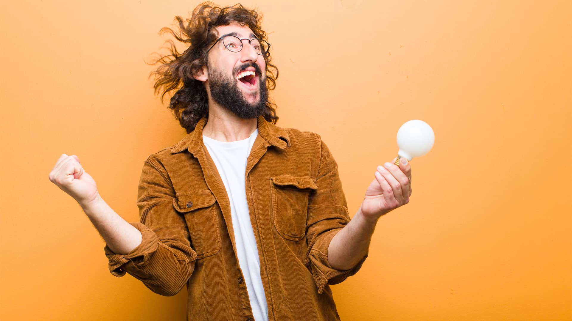 Joven con una bombilla en la mano sonríe porque ha encontrado su tarifa de luz soñada en el mercado libre Joven con una bombilla en la mano sonríe porque ha encontrado su tarifa de luz soñada en el mercado libre