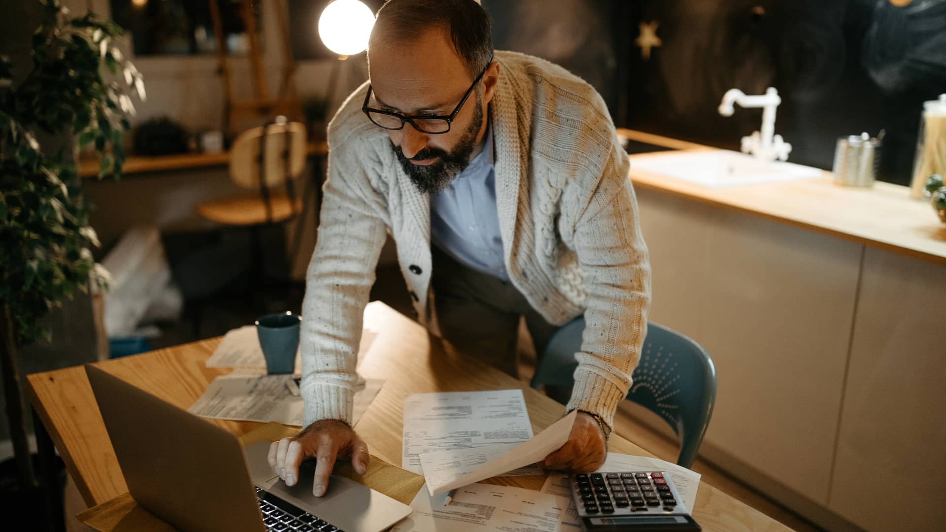 Hombre revisando facturas entre la que está la de la luz y sus peajes de acceso Hombre revisando facturas entre la que está la de la luz y sus peajes de acceso