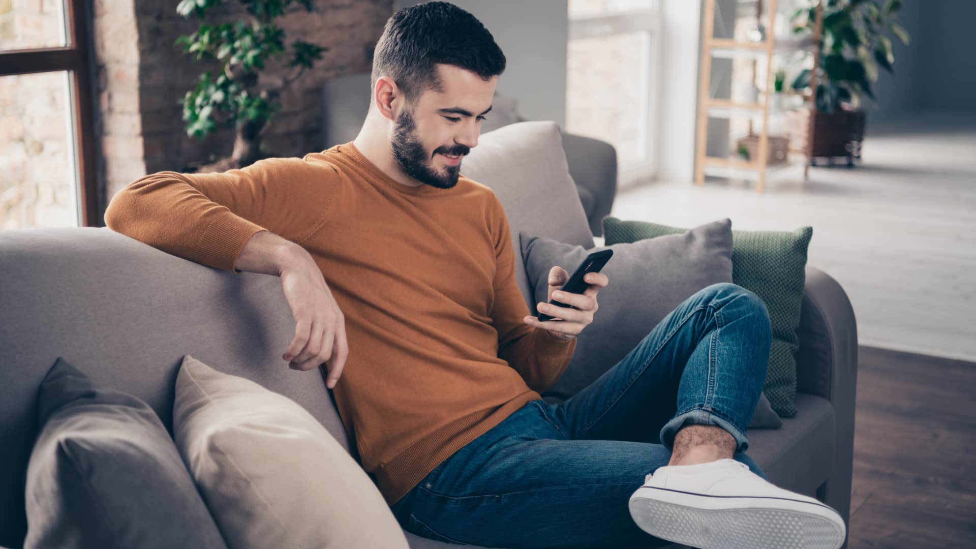 Joven informandose en su smartphone de cuanto tarda hacienda en devolver el dinero Joven informandose en su smartphone de cuanto tarda hacienda en devolver el dinero