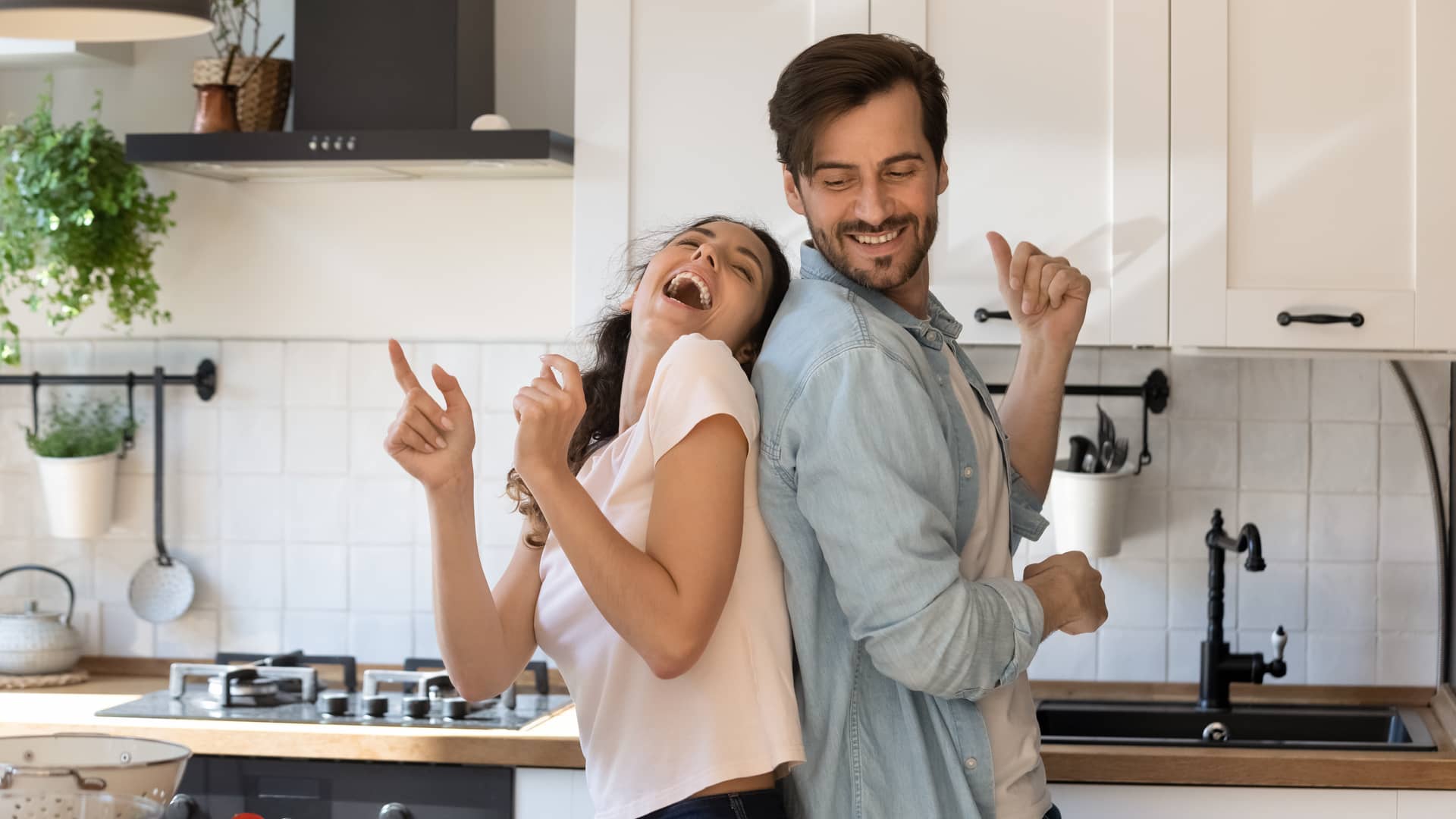 Pareja alegre en cocina es sinónimo de una buena economía doméstica