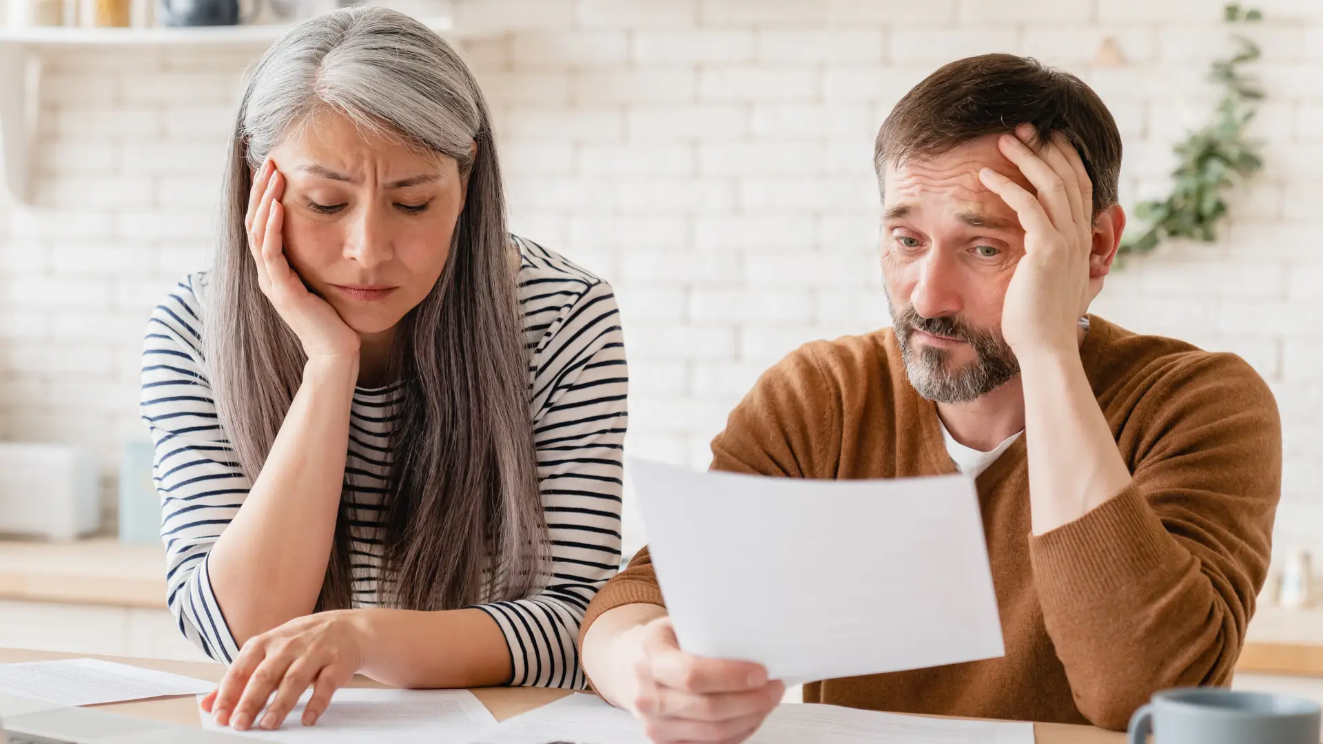 Matrimonio triste leyendo unos papeles sobre como declarar una herencia del extranjero Matrimonio triste leyendo unos papeles sobre como declarar una herencia del extranjero