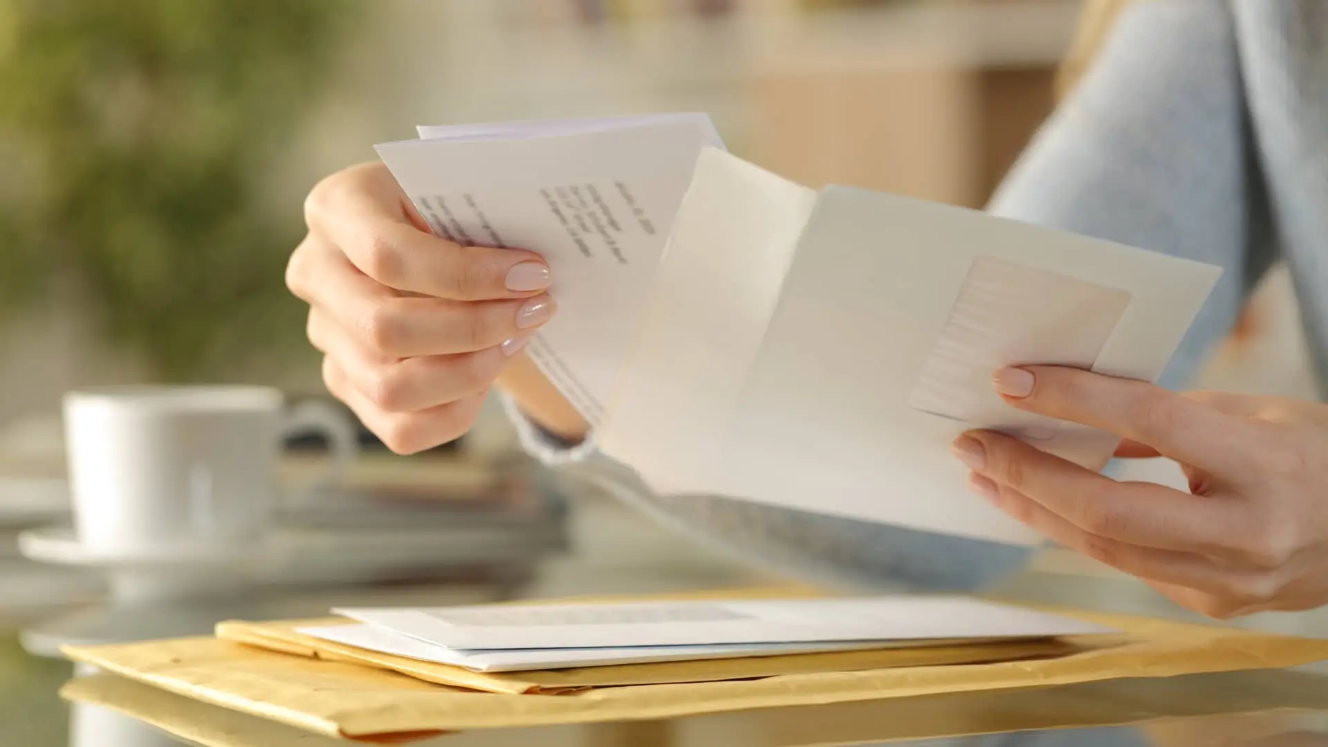 Mujer abriendo carta de certificado de titularidad