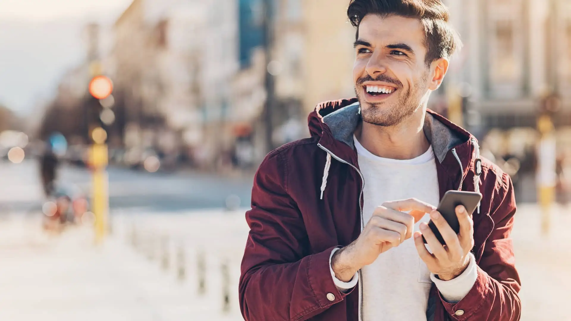 Joven sonriente viendo su cuenta sín nómina en su móvil Joven sonriente viendo su cuenta sín nómina en su móvil