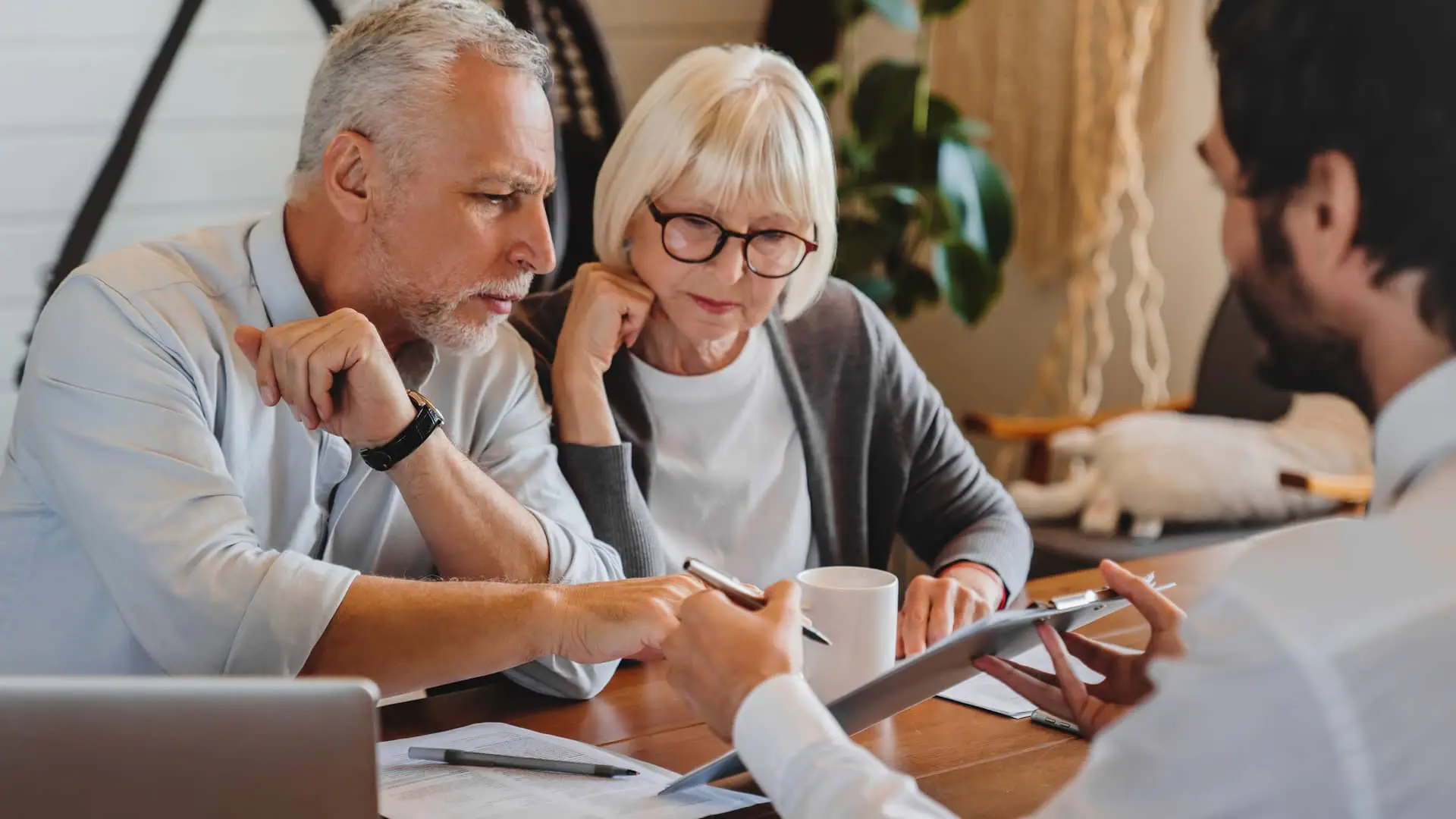 Asesor financiero explicando el papeleo a la pareja jubilada simboliza pensión Asesor financiero explicando el papeleo a la pareja jubilada simboliza pensión