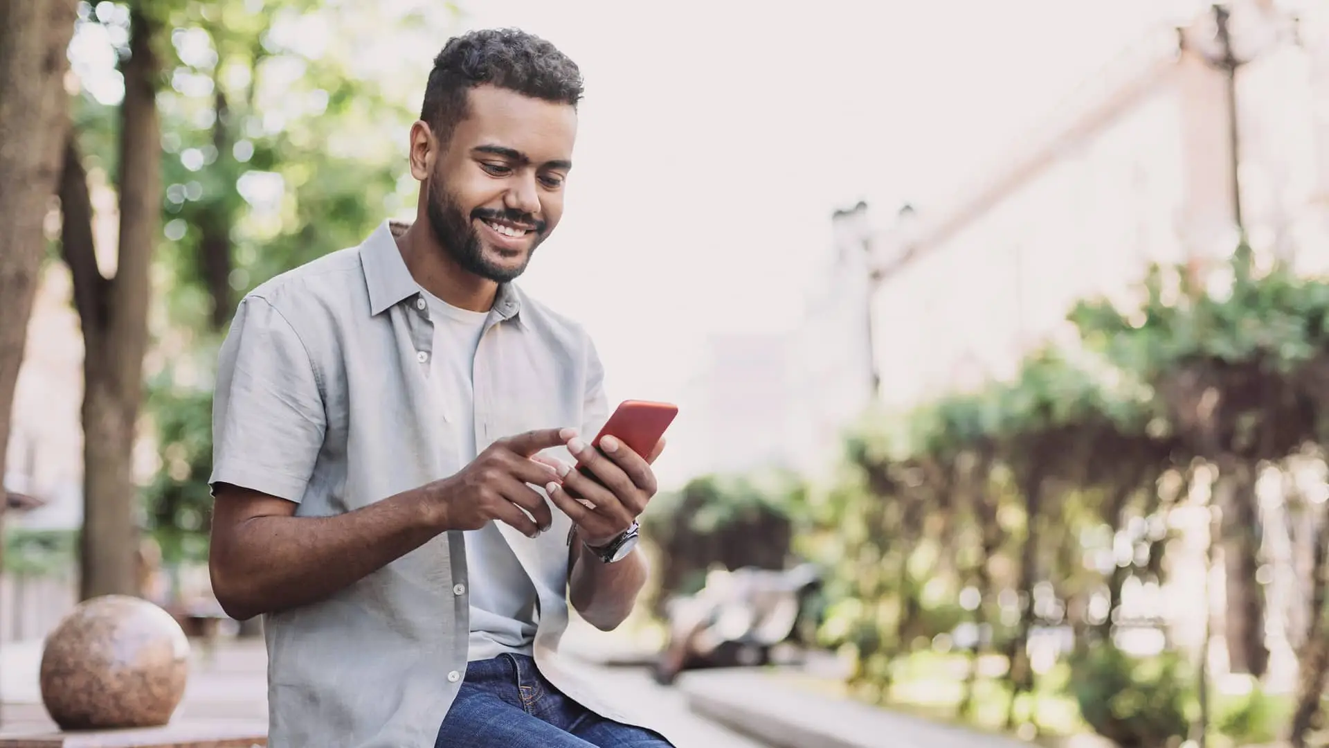 Joven realizando una transferencia internacional con su smartphone Joven realizando una transferencia internacional con su smartphone
