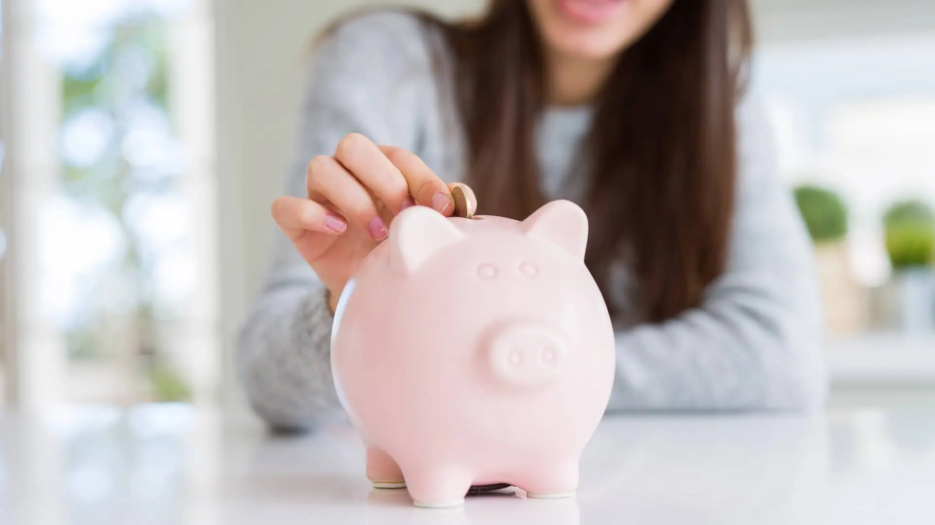 Joven introduciendo moneda en hucha simboliza depósito plan ahorro Joven introduciendo moneda en hucha simboliza depósito plan ahorro
