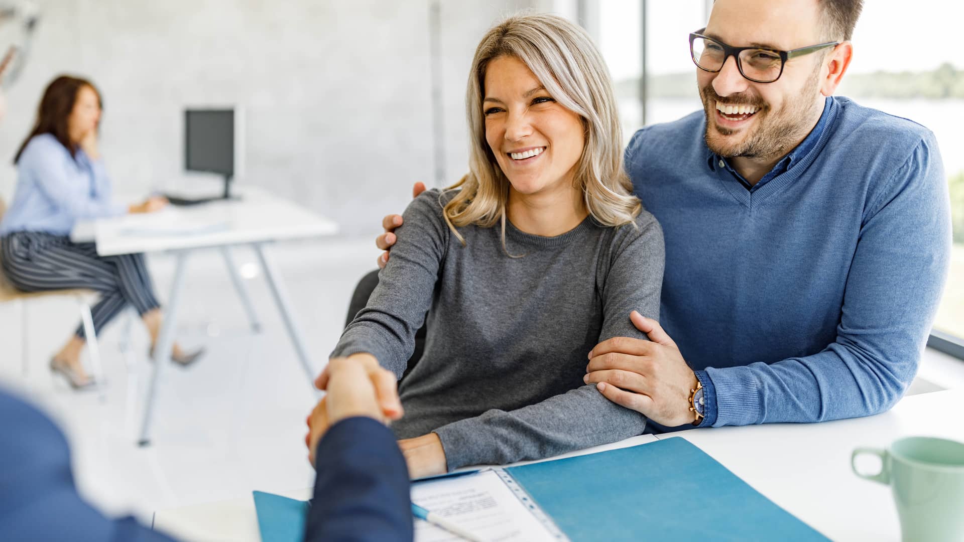 Feliz pareja llegó a un acuerdo con su asesor financiero en la oficina Feliz pareja llegó a un acuerdo con su asesor financiero en la oficina