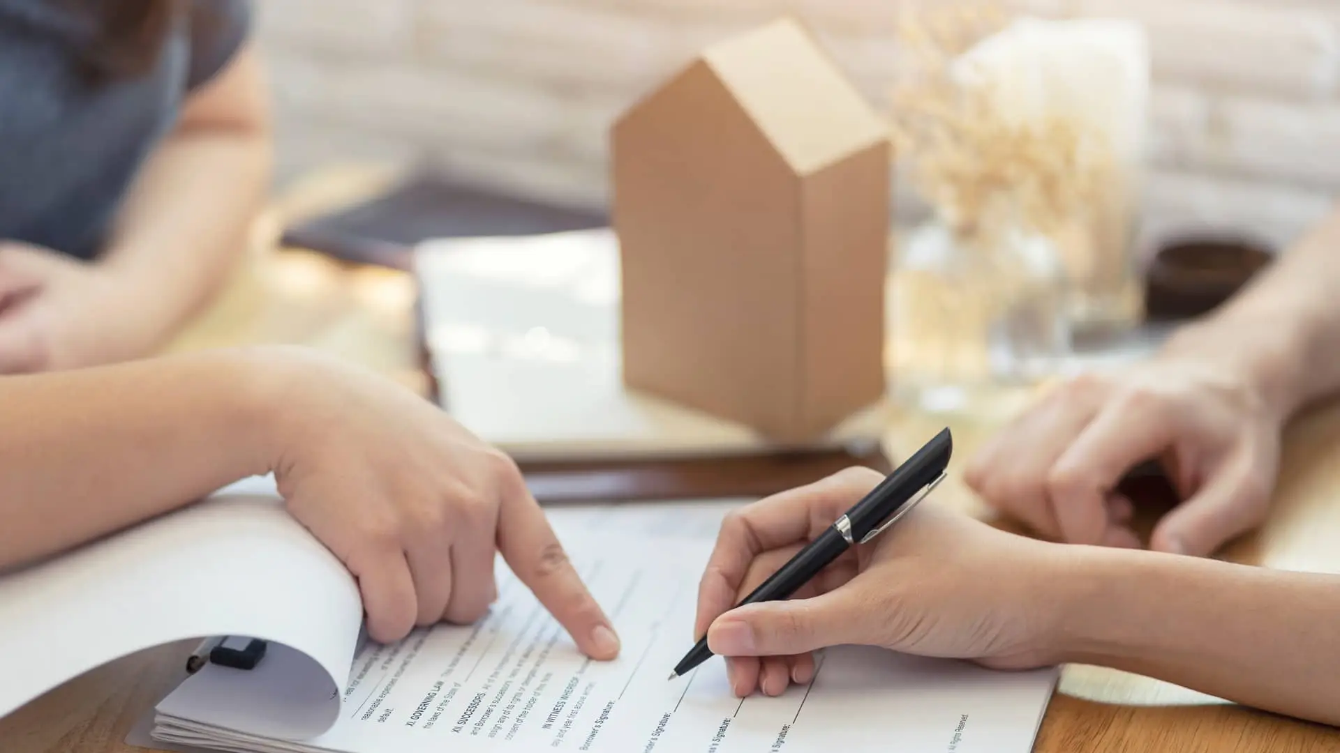Mujer firmando documentos de hipoteca de abanca