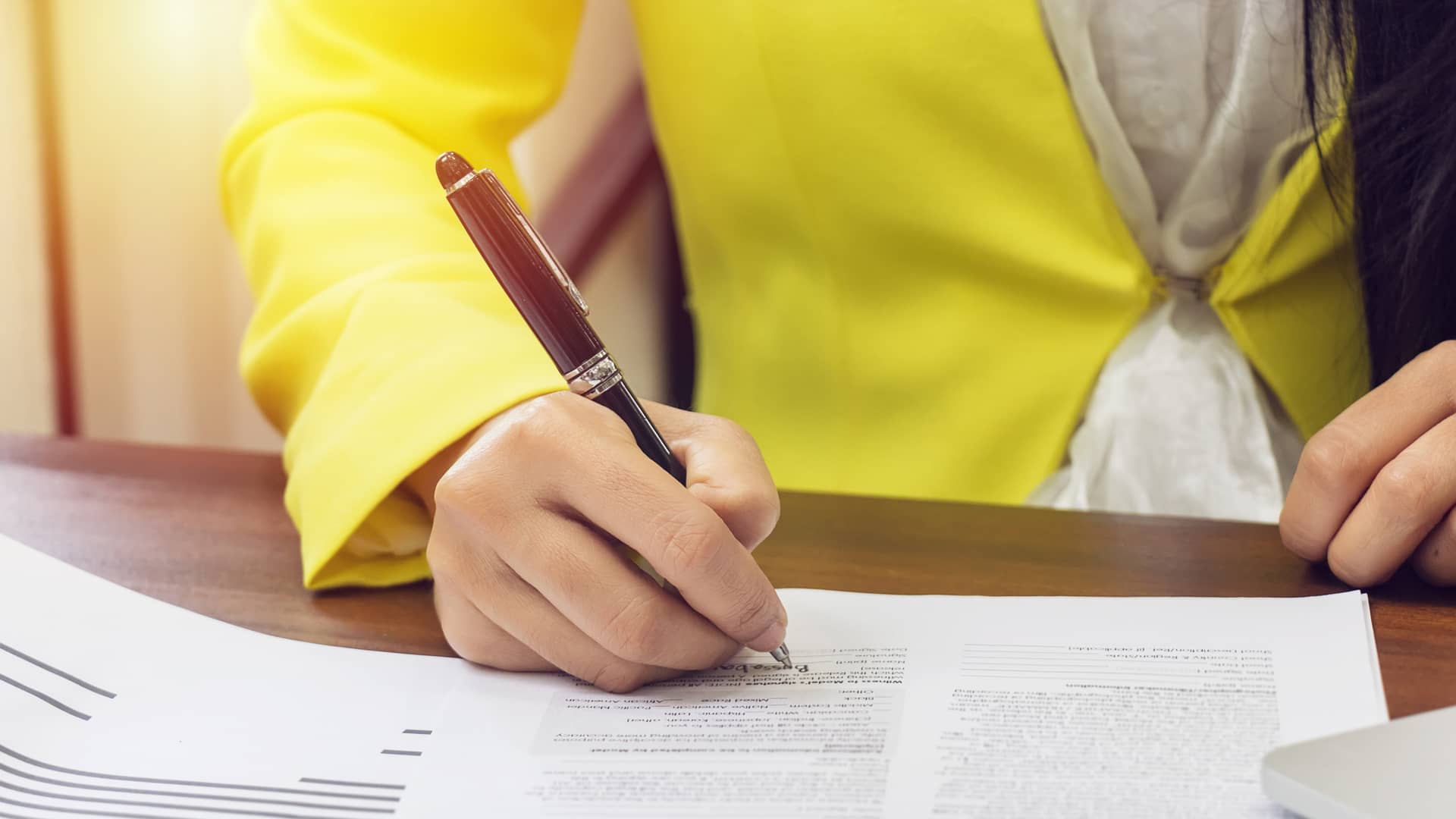 Mujer firmando contrato de hipoteca de banco pichincha