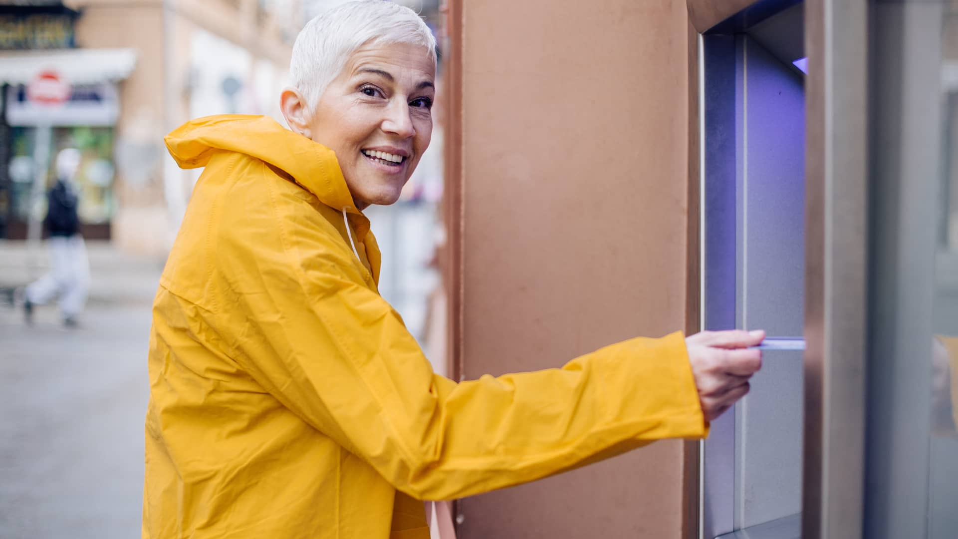 Mujer sacando dinero en cajero automático de oficina de banco pichincha