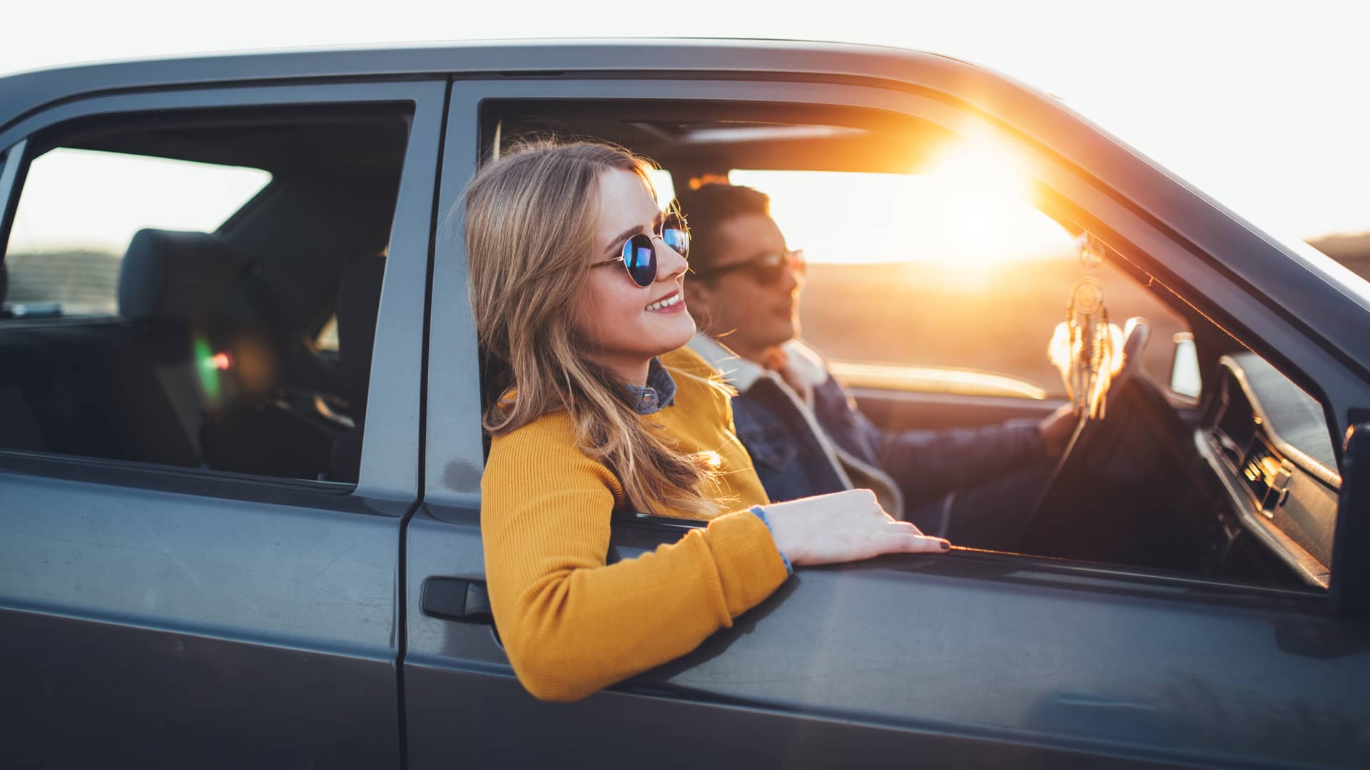 Mujer disfrutando de viaje con su pareja en su coche asegurado con banco pichincha Mujer disfrutando de viaje con su pareja en su coche asegurado con banco pichincha