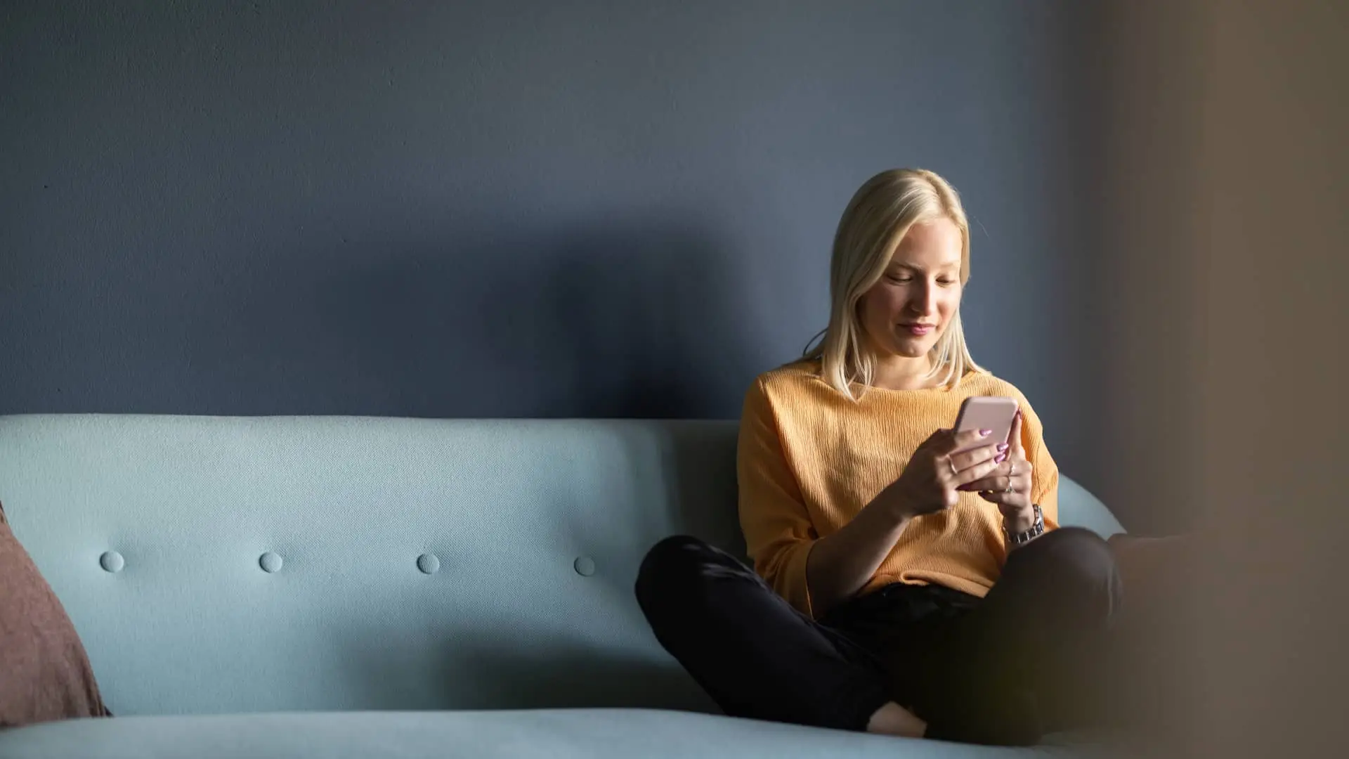 Mujer sentada en sofá viendo sus cuentas bancarias de bankinter