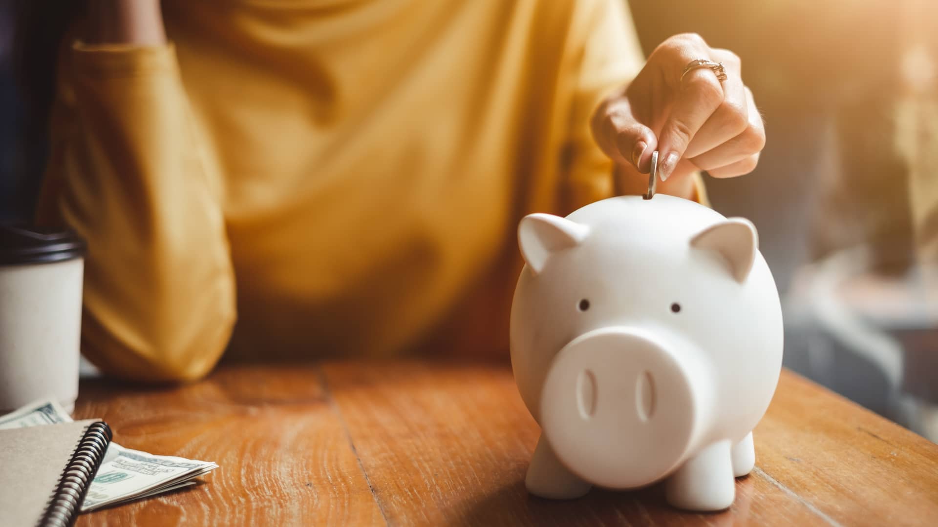 Mujer echando dinero en la hucha deposito bankinter