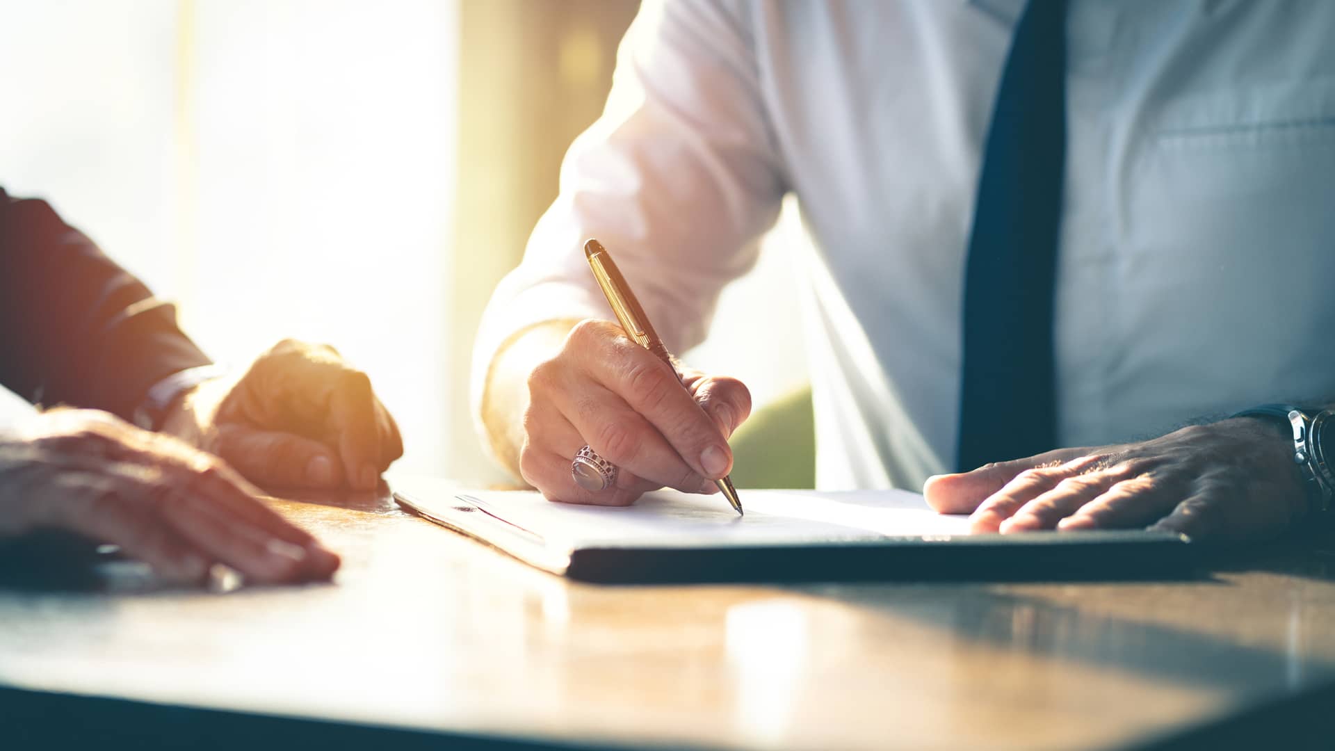 Hombre firmando papeles de contrato de hipoteca bbva