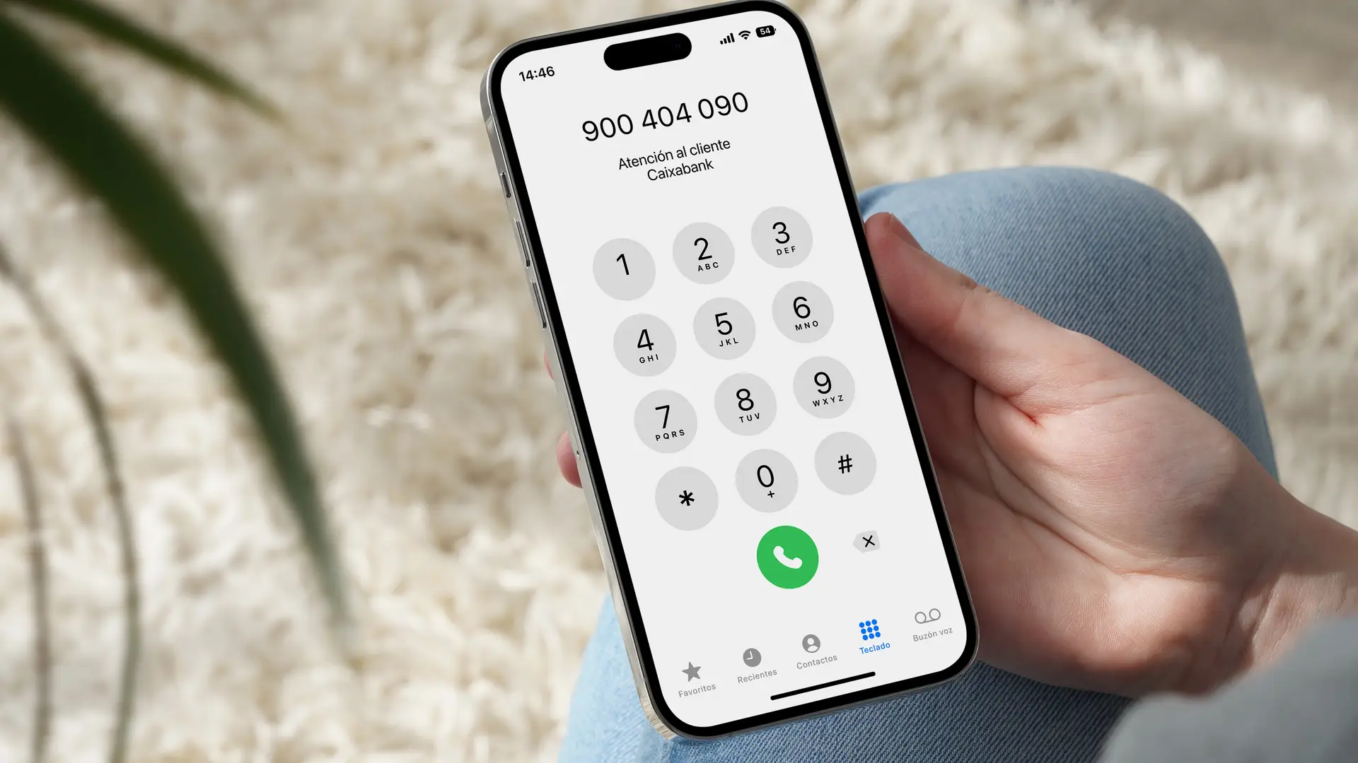 Una persona llamando por teléfono al 900 404 090 que es el número de atención al cliente de Caixabank