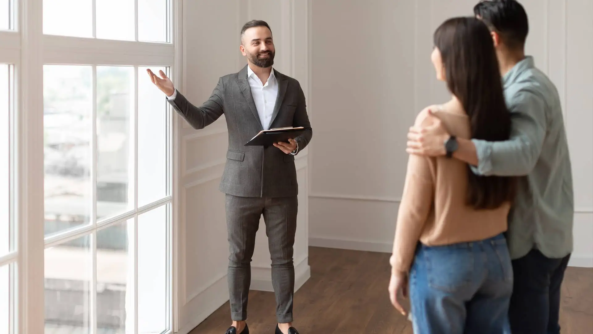 Agente de inmobiliaria de caixabank enseñando casa a pareja Agente de inmobiliaria de caixabank enseñando casa a pareja