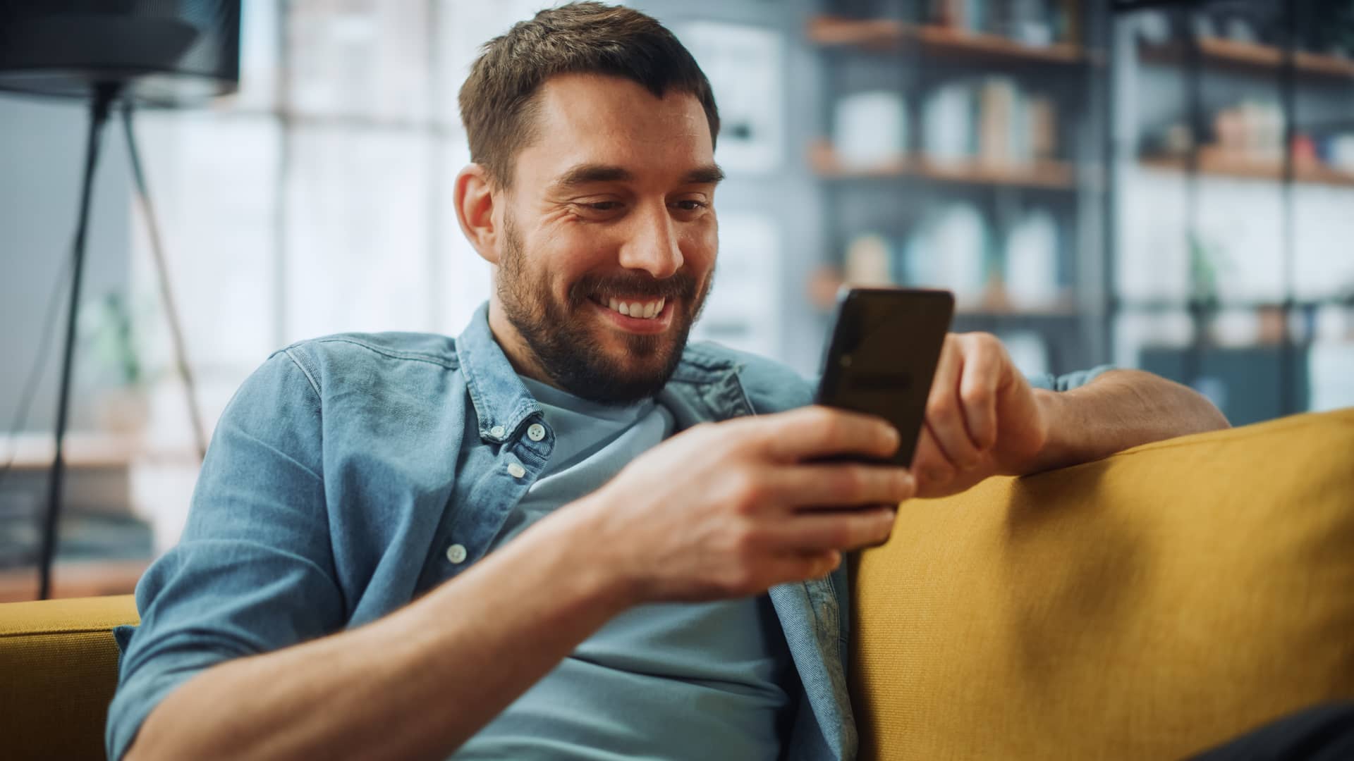 Hombre viendo su cuenta de caixbank online con su smartphone