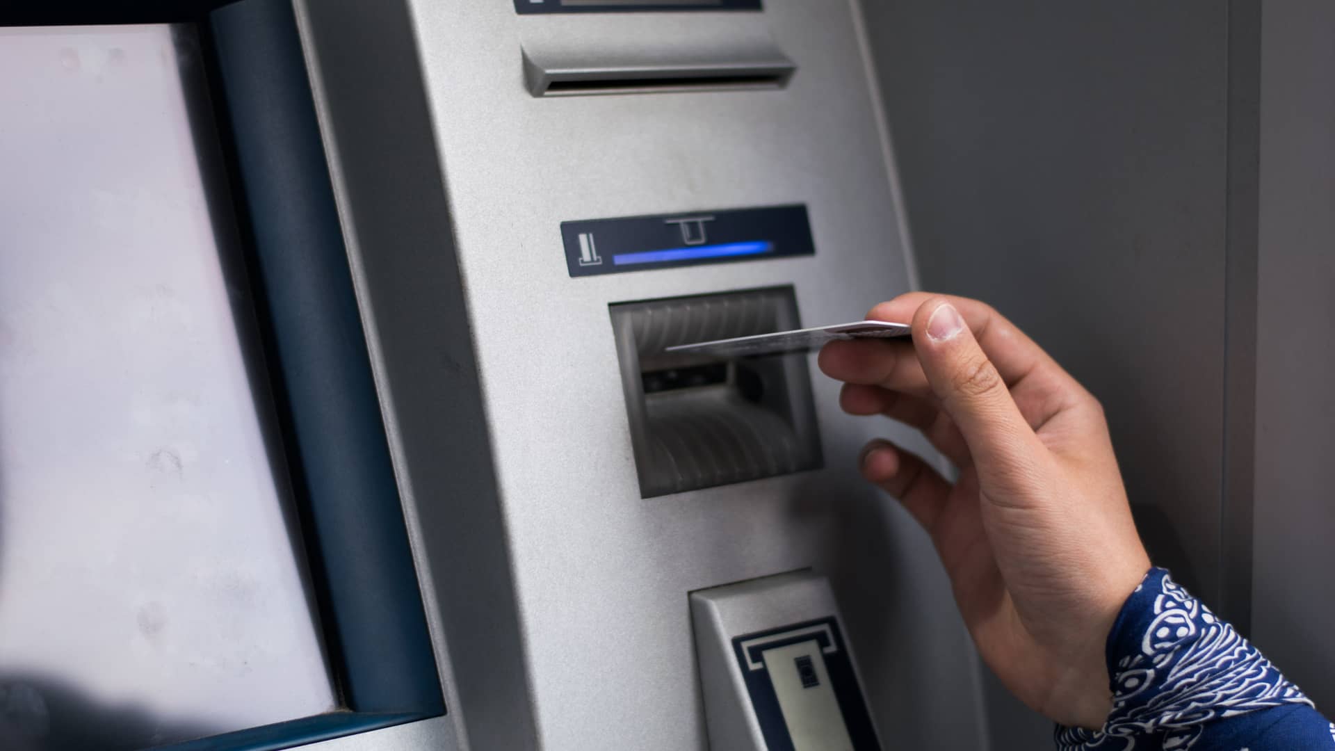 Joven introduciendo tarjeta de crédito en cajero automático de oficinas de cajasiete