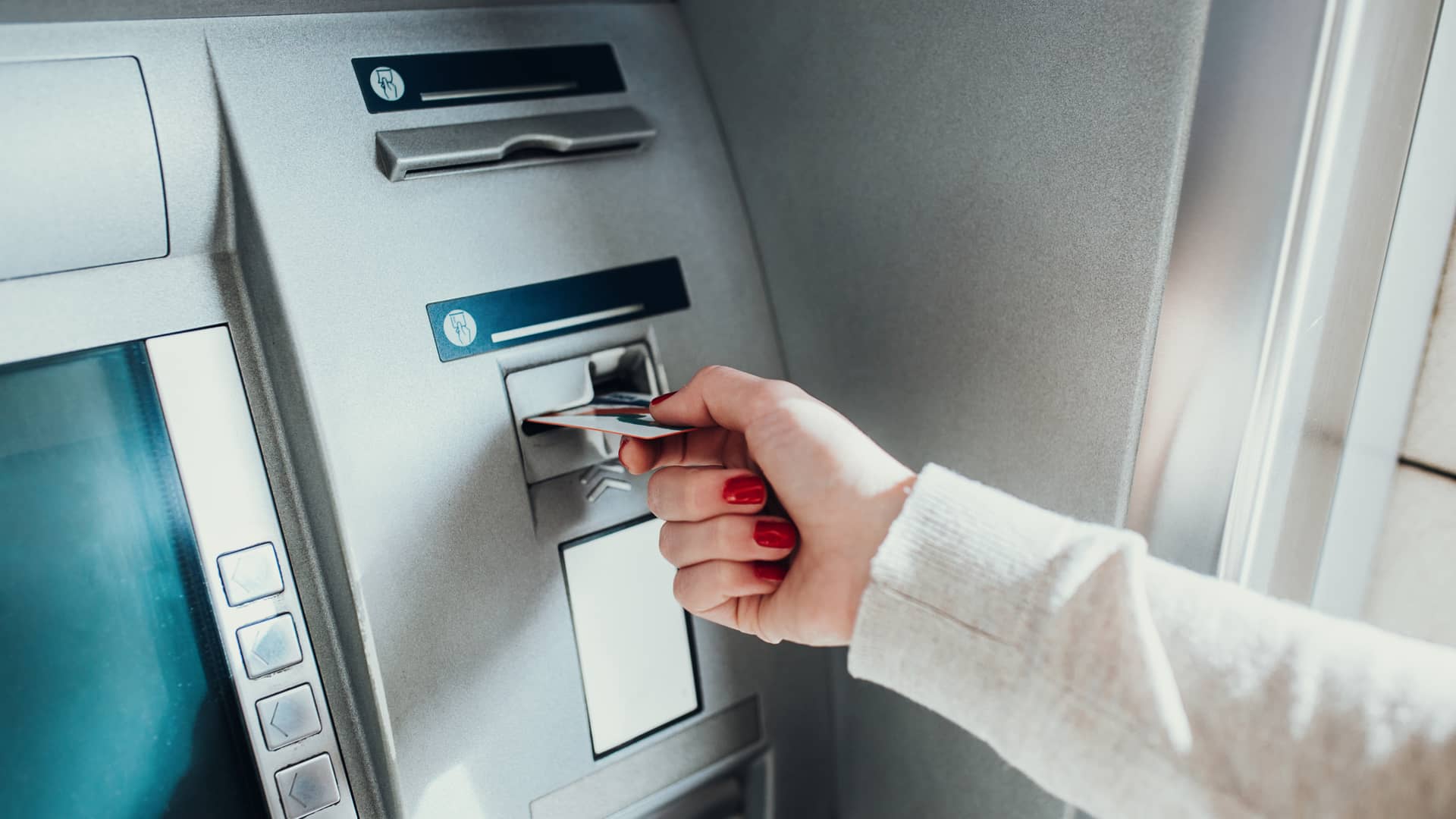Mujer introduciendo tarjeta de crédito en cajero automático de oficinas de cajasur Mujer introduciendo tarjeta de crédito en cajero automático de oficinas de cajasur