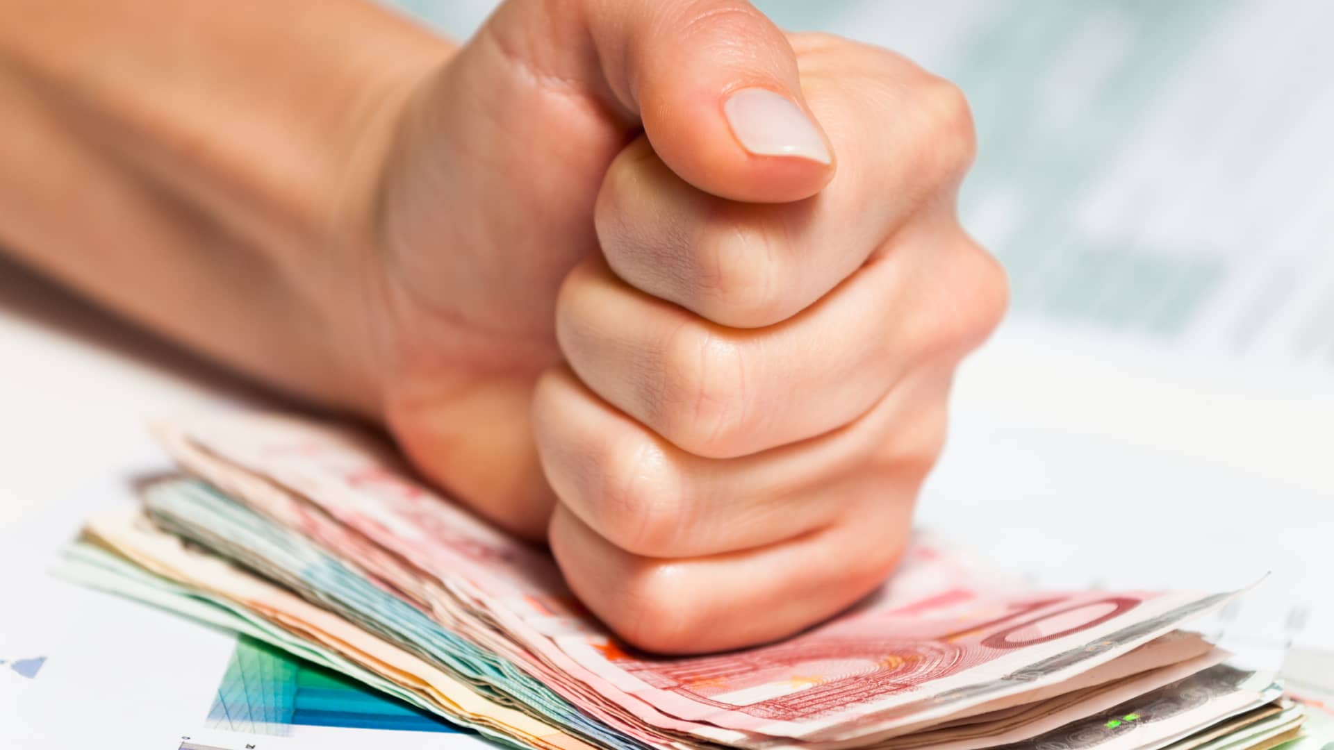 Persona golpeando con el puño fuertemente dinero de prestamo cajasur para que no se vuele Persona golpeando con el puño fuertemente dinero de prestamo cajasur para que no se vuele