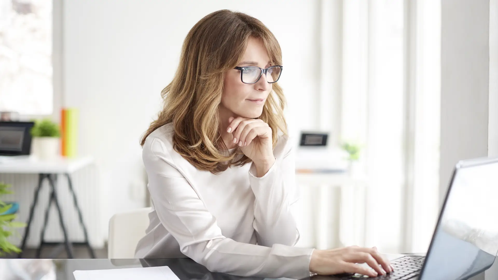 Una mujer con el ordenaodr obteniendo información sobre los depósitos de EBN banco Una mujer con el ordenaodr obteniendo información sobre los depósitos de EBN banco