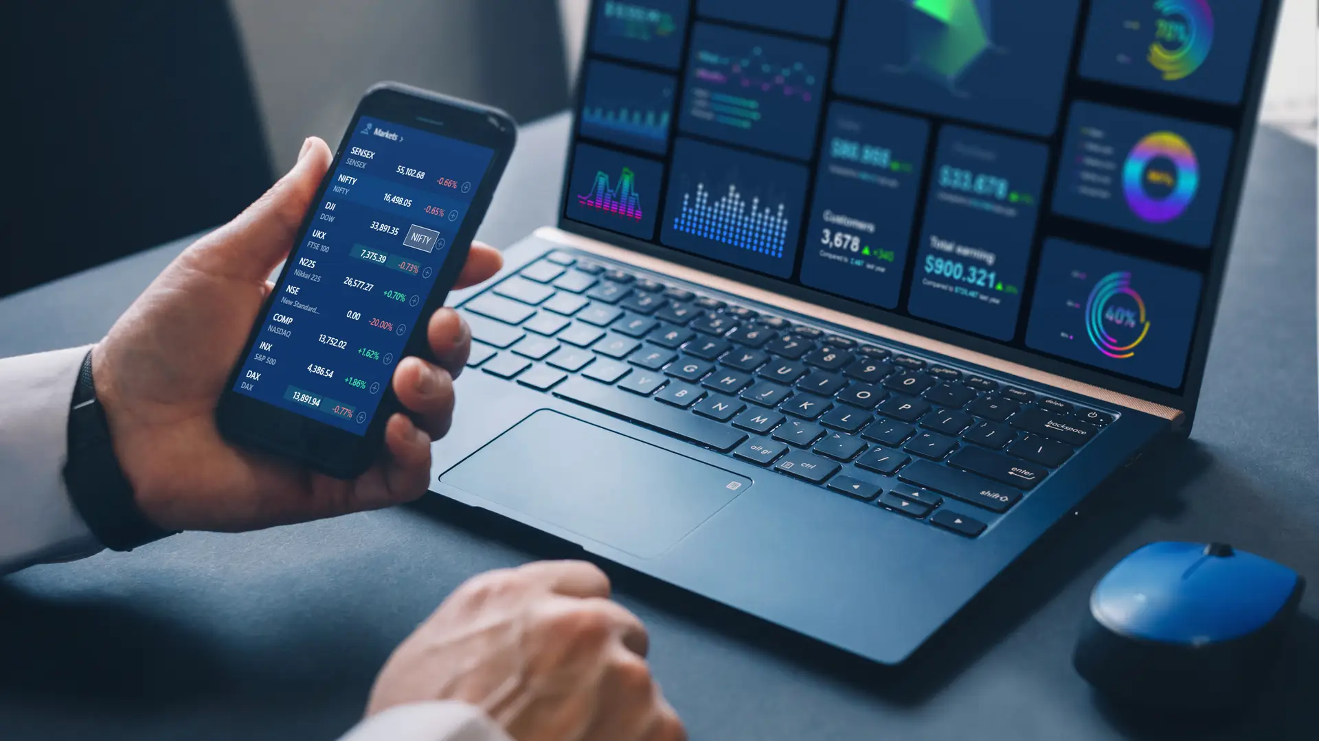 Una persona revisando la bolsa con el movil y el ordenador que forma parte del broker de Imaginbank