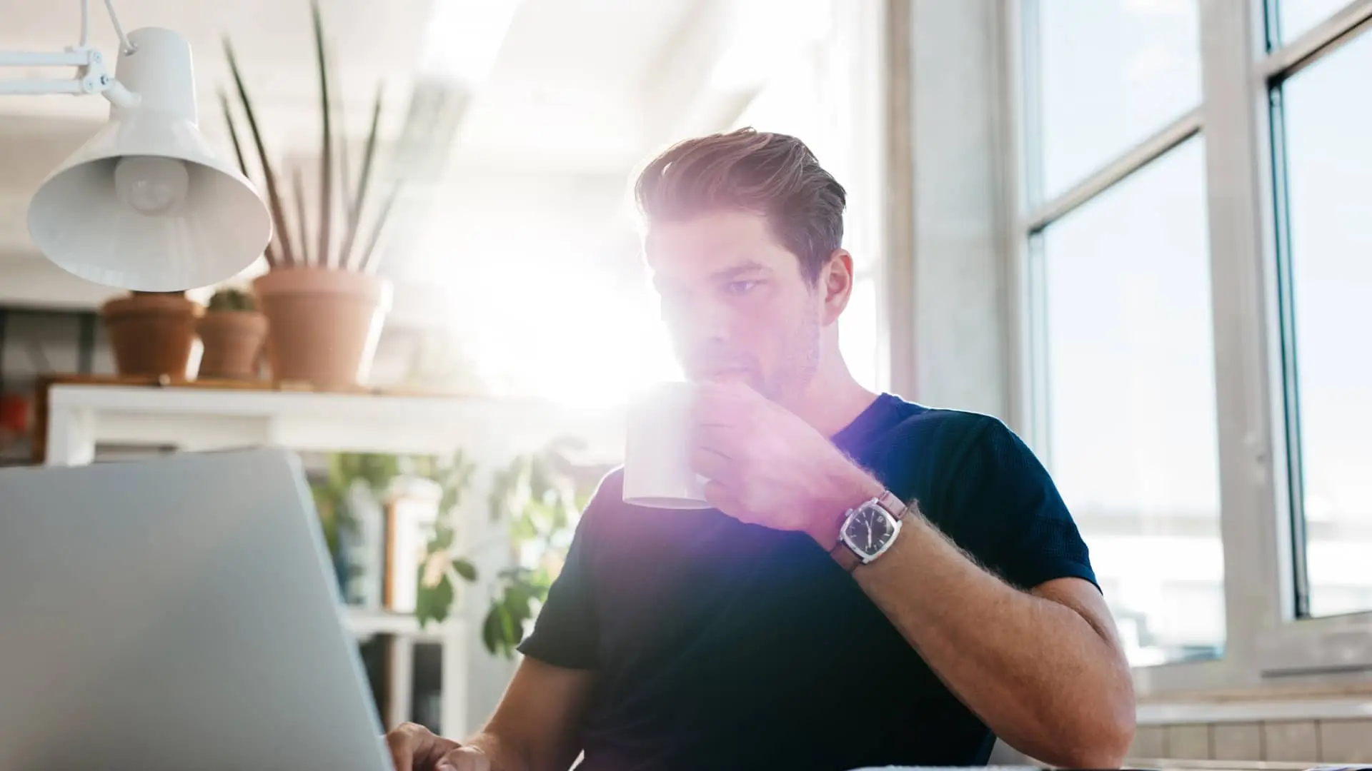 Hombre viendo sus cuentas de imaginbank con su laptop mientras desayuna Hombre viendo sus cuentas de imaginbank con su laptop mientras desayuna
