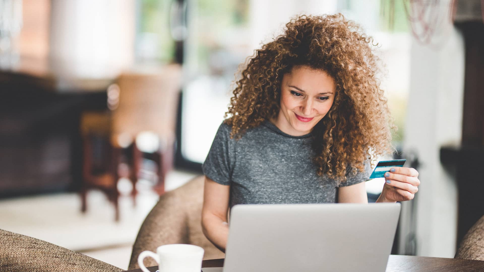 Mujer realizando compras online con su tarjeta aprovechando los descuentos que ofrece imaginbank