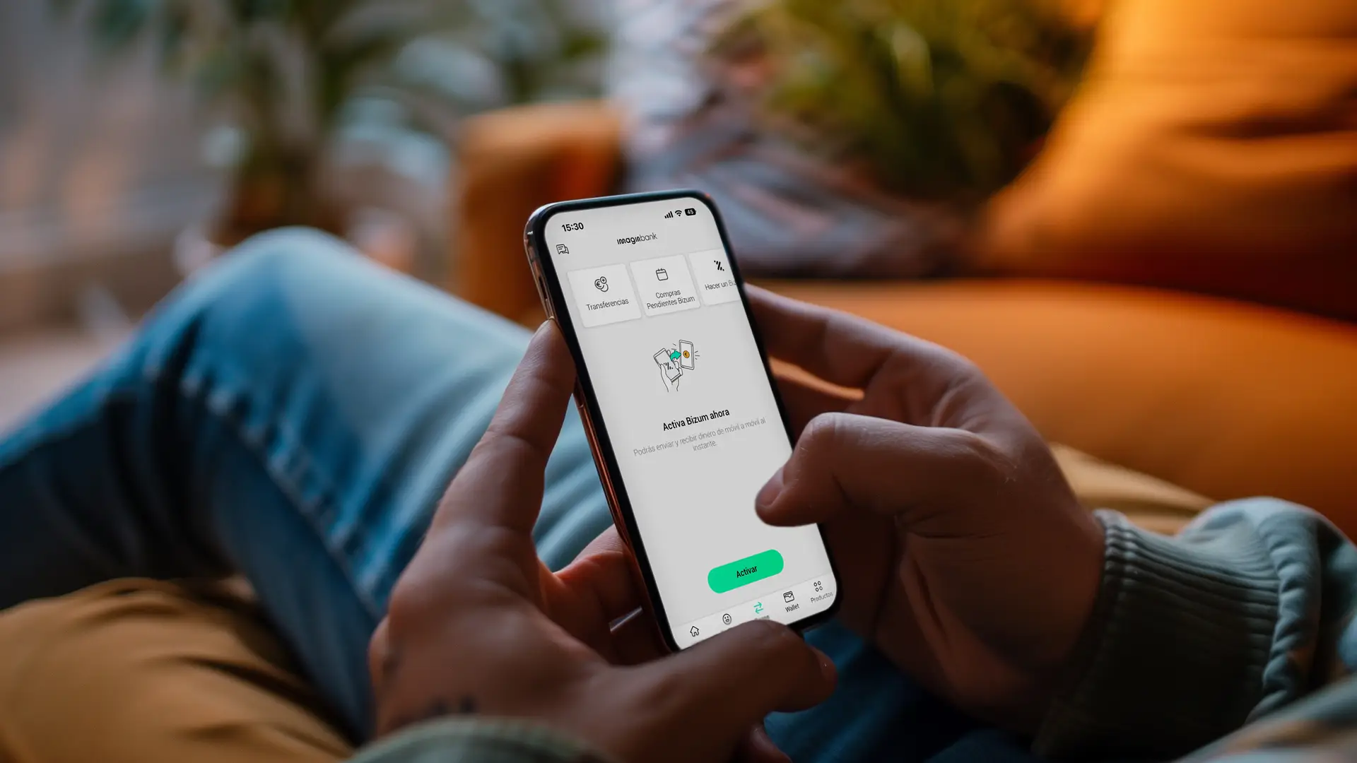 Hombre sujetando un móvil con la app de imaginbank en la pantalla mientras hace una transferencia financiera. Hombre sujetando un móvil con la app de imaginbank en la pantalla mientras hace una transferencia financiera.