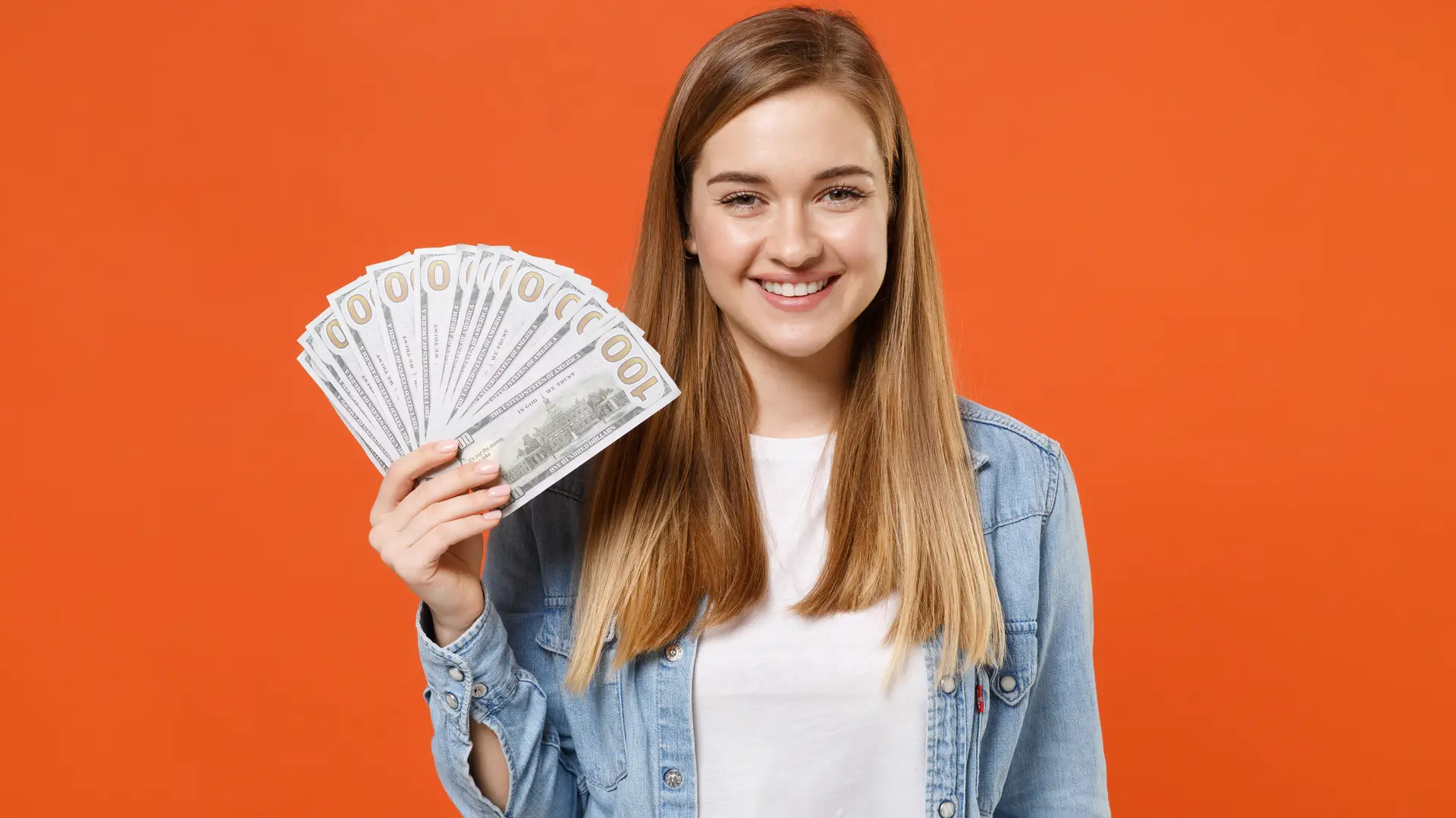 Una chica con billetes en un fondo naranja para representar los depositos de ING Una chica con billetes en un fondo naranja para representar los depositos de ING