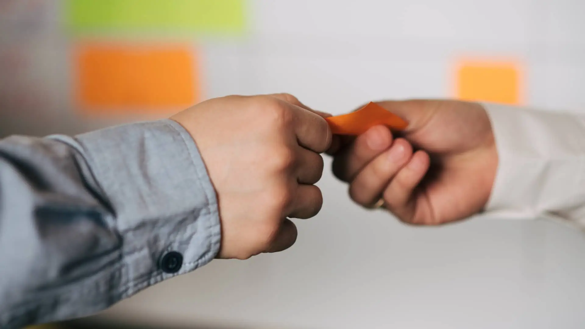 Joven dando posit con número de cuenta a mujer para que realice una transferencia