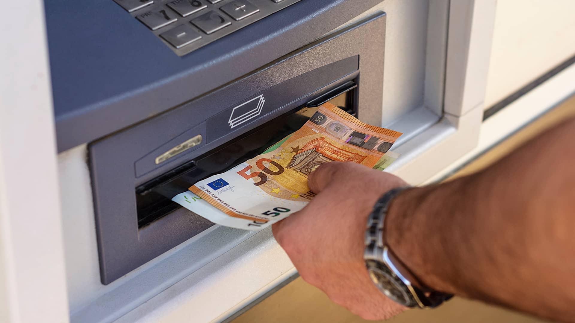 Hombre sacando dinero de cajero sín tarjeta de crédito Hombre sacando dinero de cajero sín tarjeta de crédito