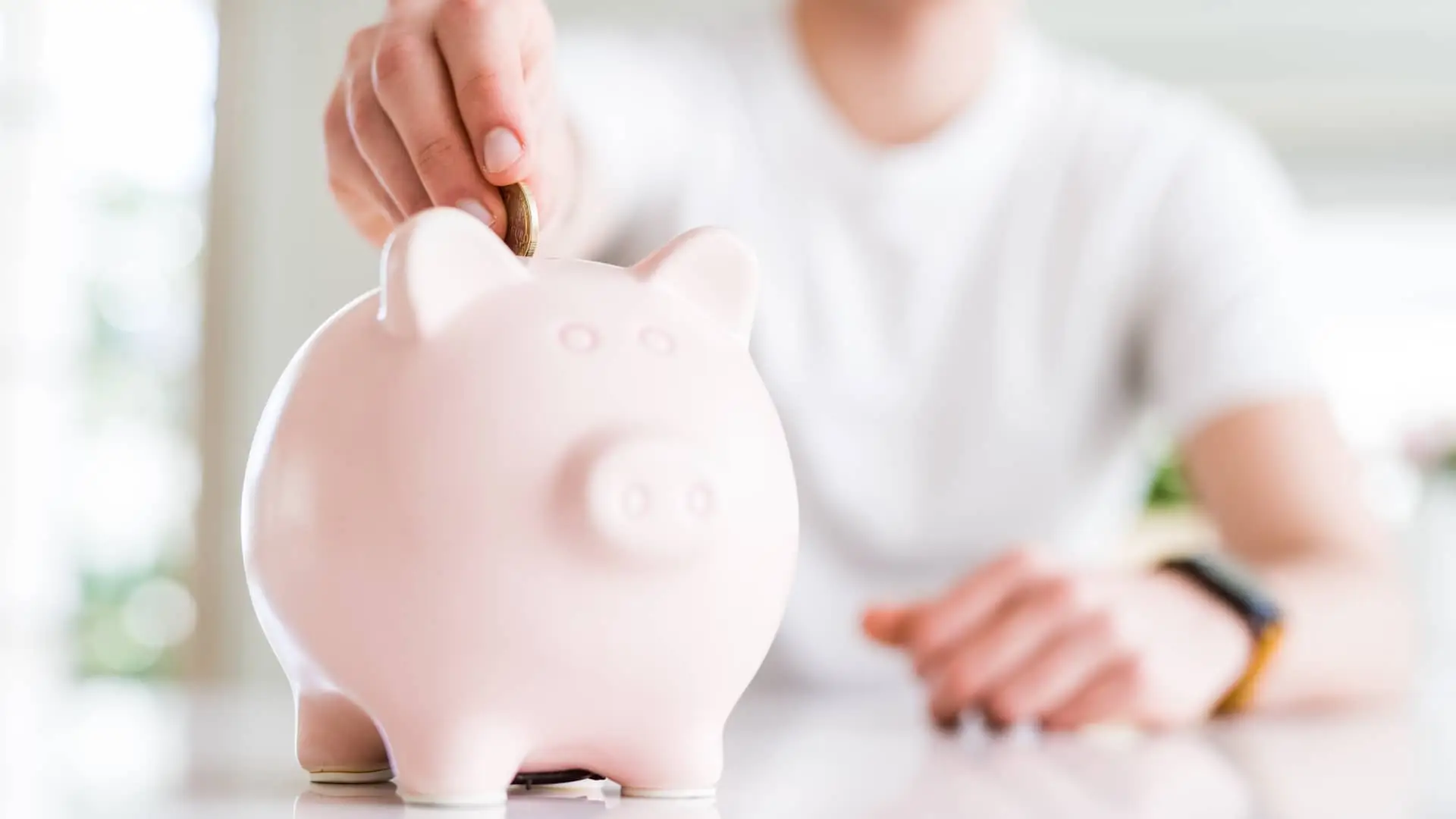 Hombre introduciendo moneda en hucha simboliza depositos mediolanum Hombre introduciendo moneda en hucha simboliza depositos mediolanum