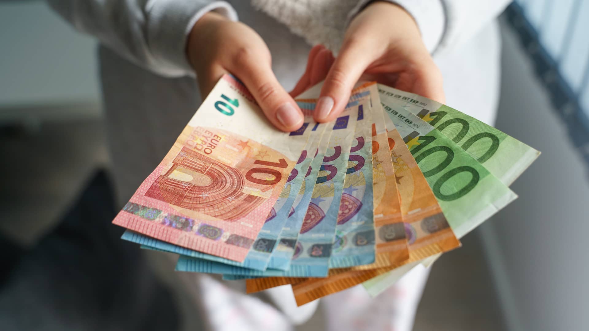 Mujer está mirando billetes en efectivo de su prestamo pensando en como actuar con él Mujer está mirando billetes en efectivo de su prestamo pensando en como actuar con él