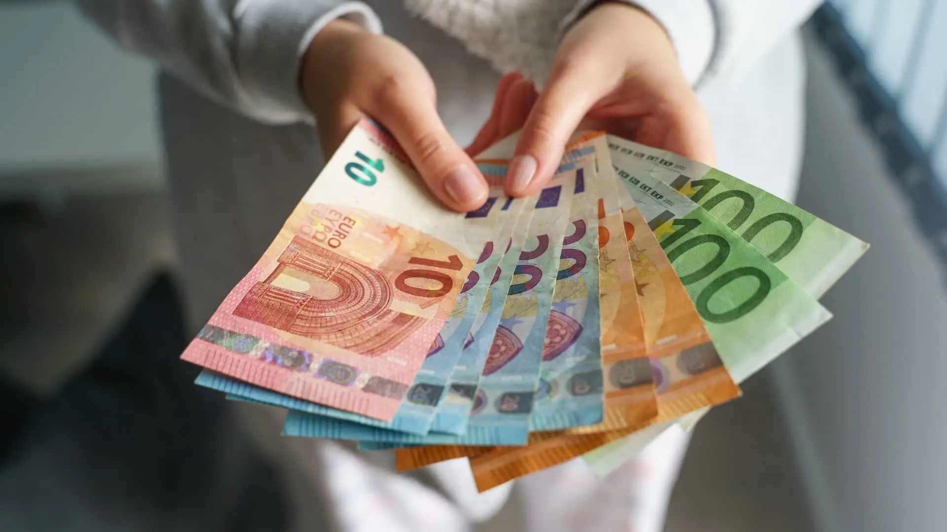 Mujer está mirando billetes en efectivo de su prestamo pensando en como actuar con él Mujer está mirando billetes en efectivo de su prestamo pensando en como actuar con él