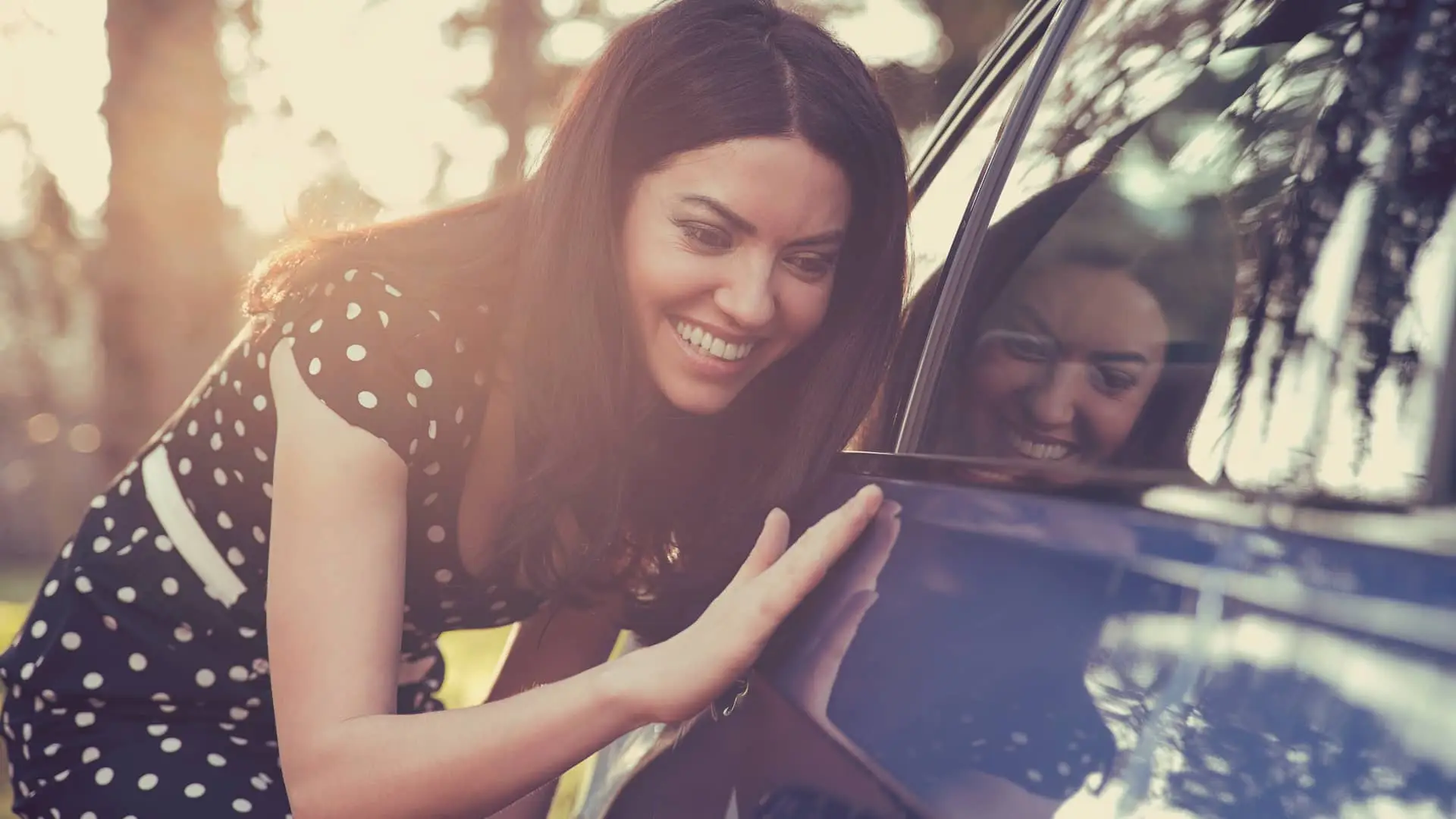 Mujer limpiando su coche asegurado con seguro openbank Mujer limpiando su coche asegurado con seguro openbank