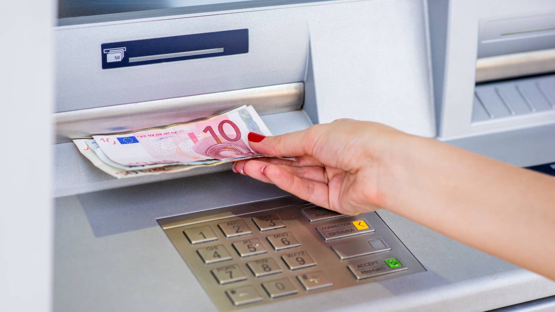 Joven retirando dinero de cajero de oficina pibank Joven retirando dinero de cajero de oficina pibank