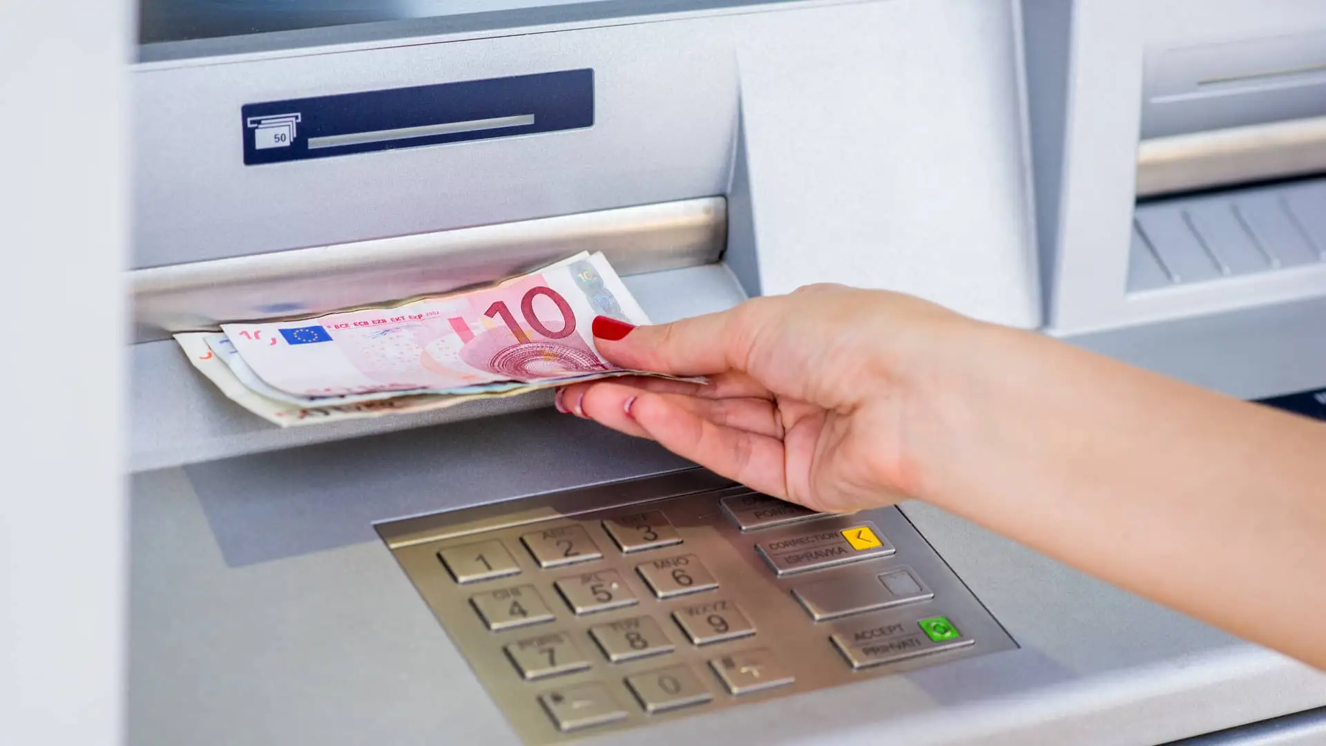 Joven retirando dinero de cajero de oficina pibank Joven retirando dinero de cajero de oficina pibank