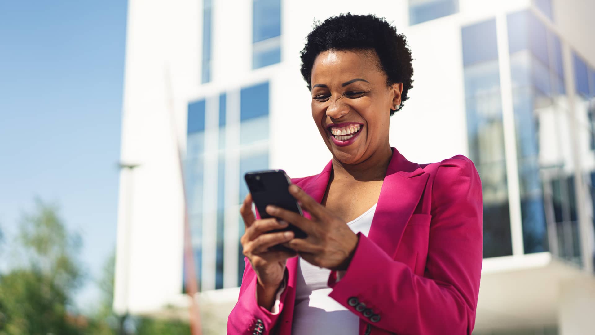 Mujer sonriente viendo en su smartphone sus cuentas Mujer sonriente viendo en su smartphone sus cuentas