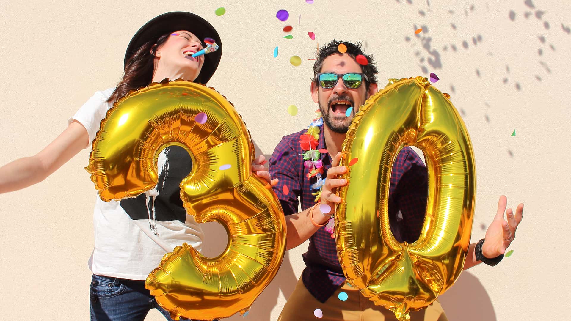 Pareja celebrando su cumpleaños con globos con forma de número 30, representando las hipotecas a 30 años Pareja celebrando su cumpleaños con globos con forma de número 30, representando las hipotecas a 30 años