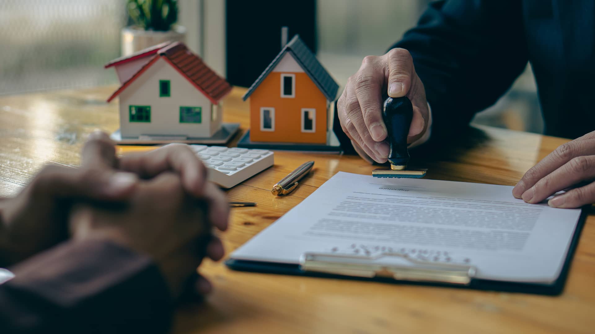 Notario sellando un contrato de hipoteca tras revisar el certificado de deuda pendiente de hipoteca Notario sellando un contrato de hipoteca tras revisar el certificado de deuda pendiente de hipoteca