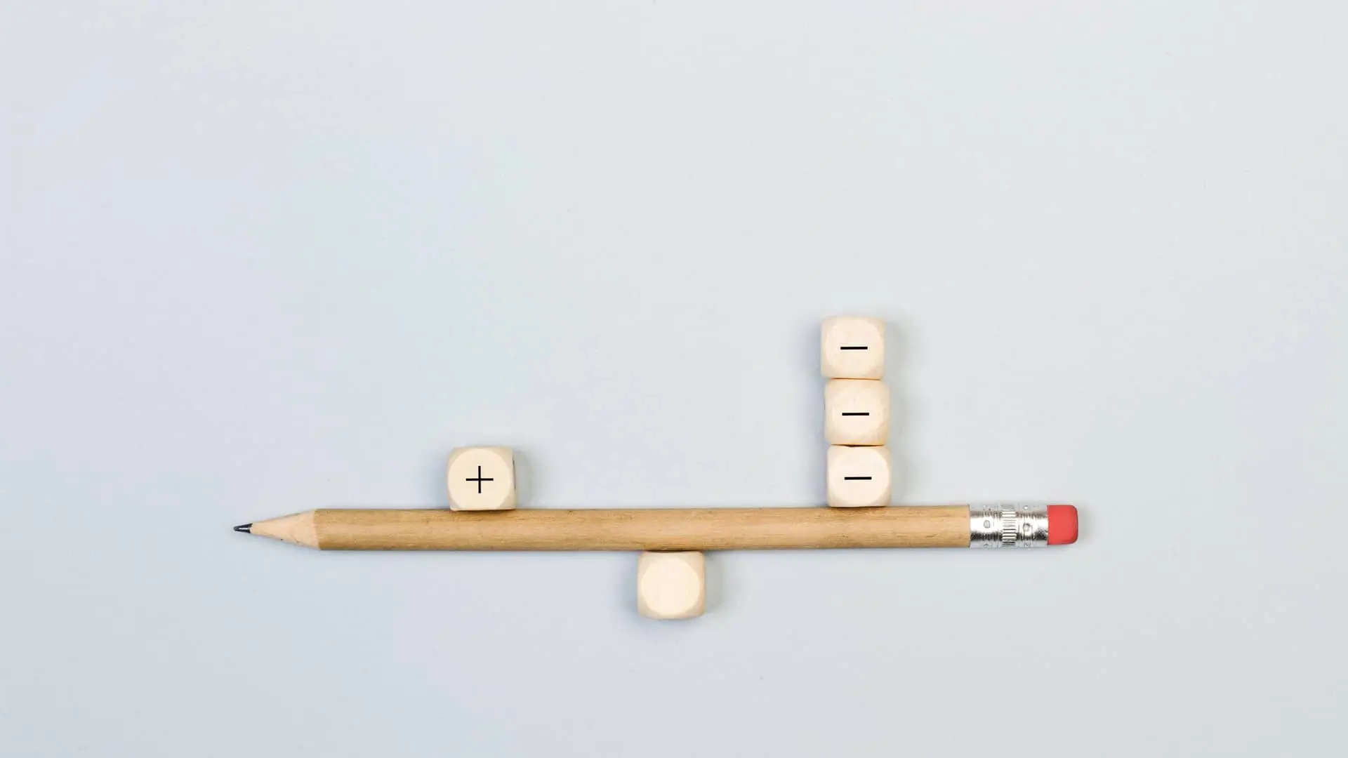 Balanza hecha con lápiz y dados con símbolo más y menos simboliza comisiones de hipotecas Balanza hecha con lápiz y dados con símbolo más y menos simboliza comisiones de hipotecas